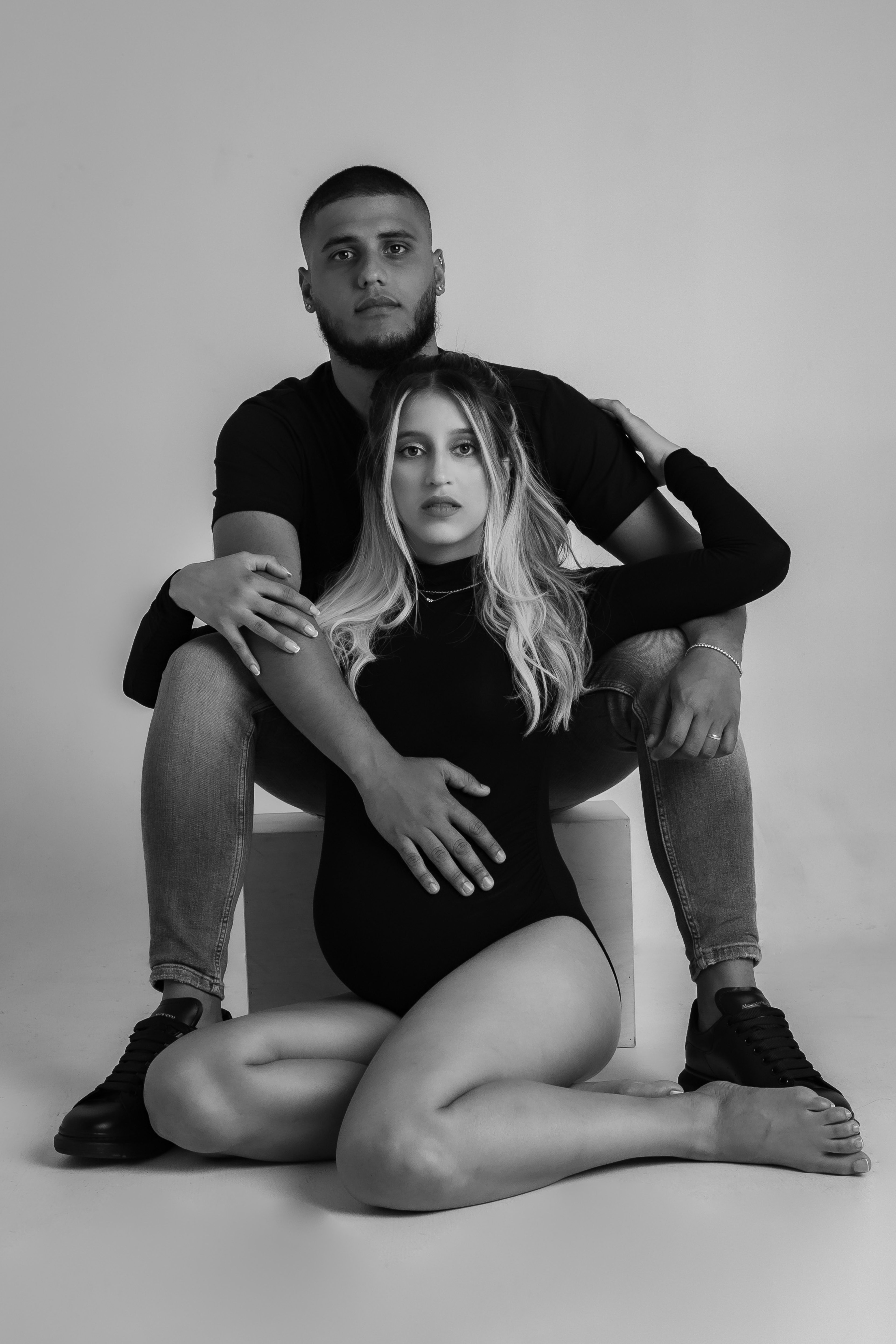 A black and white maternity photo shoot with a man and a woman.