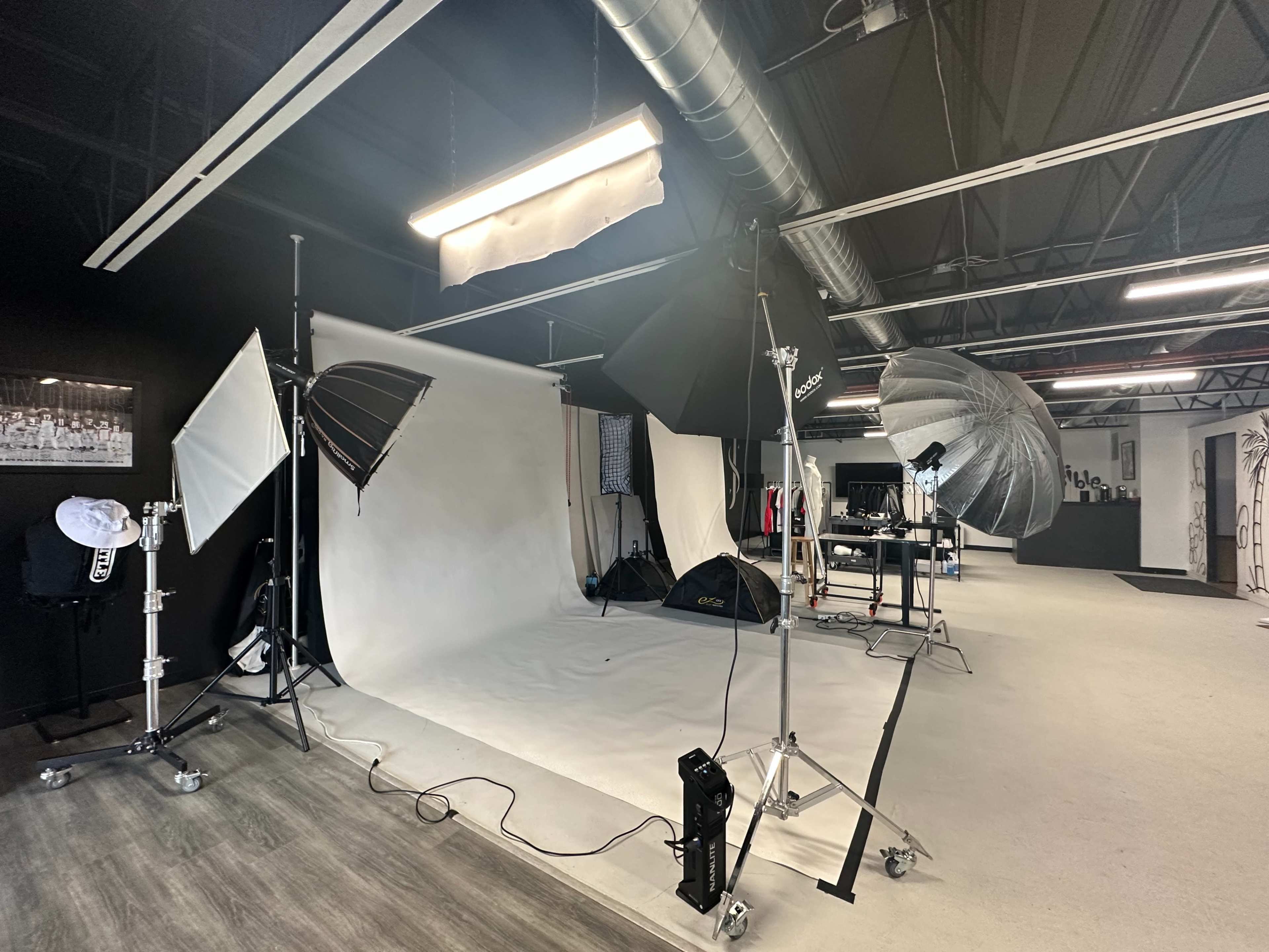 A photography studio equipped with various lighting equipment and a backdrop setup.