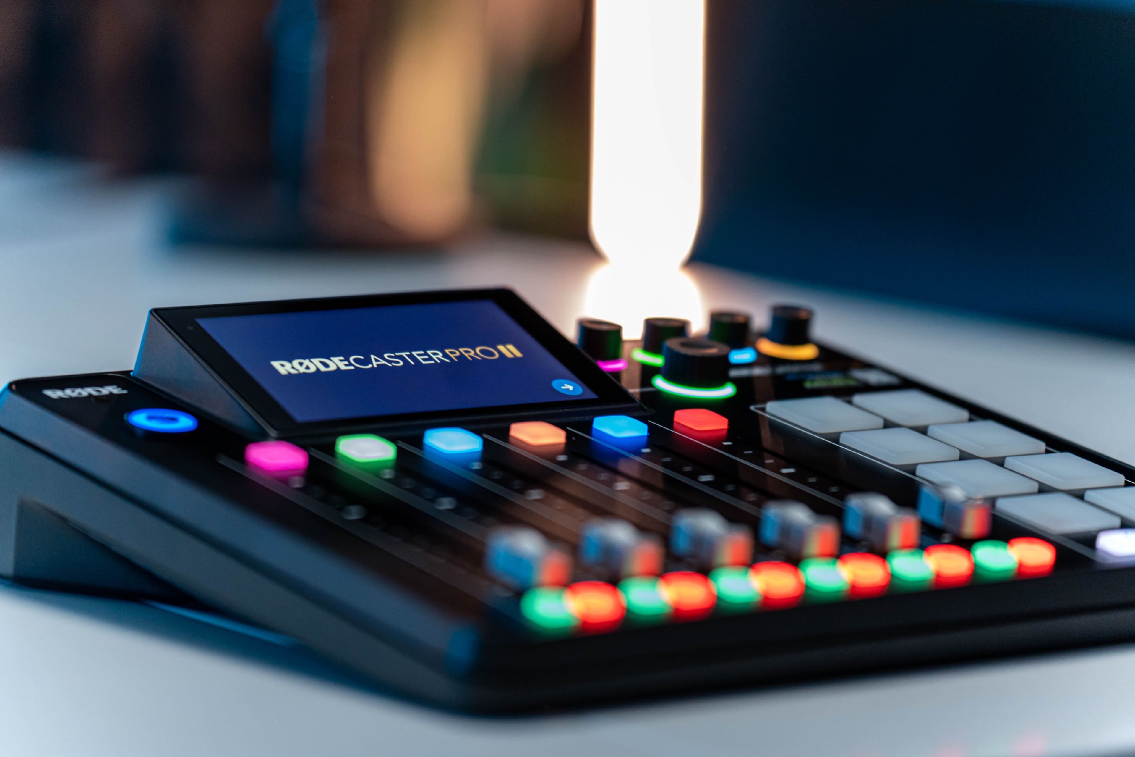 A Rodecaster Pro II audio mixing console with colorful buttons and a digital display.