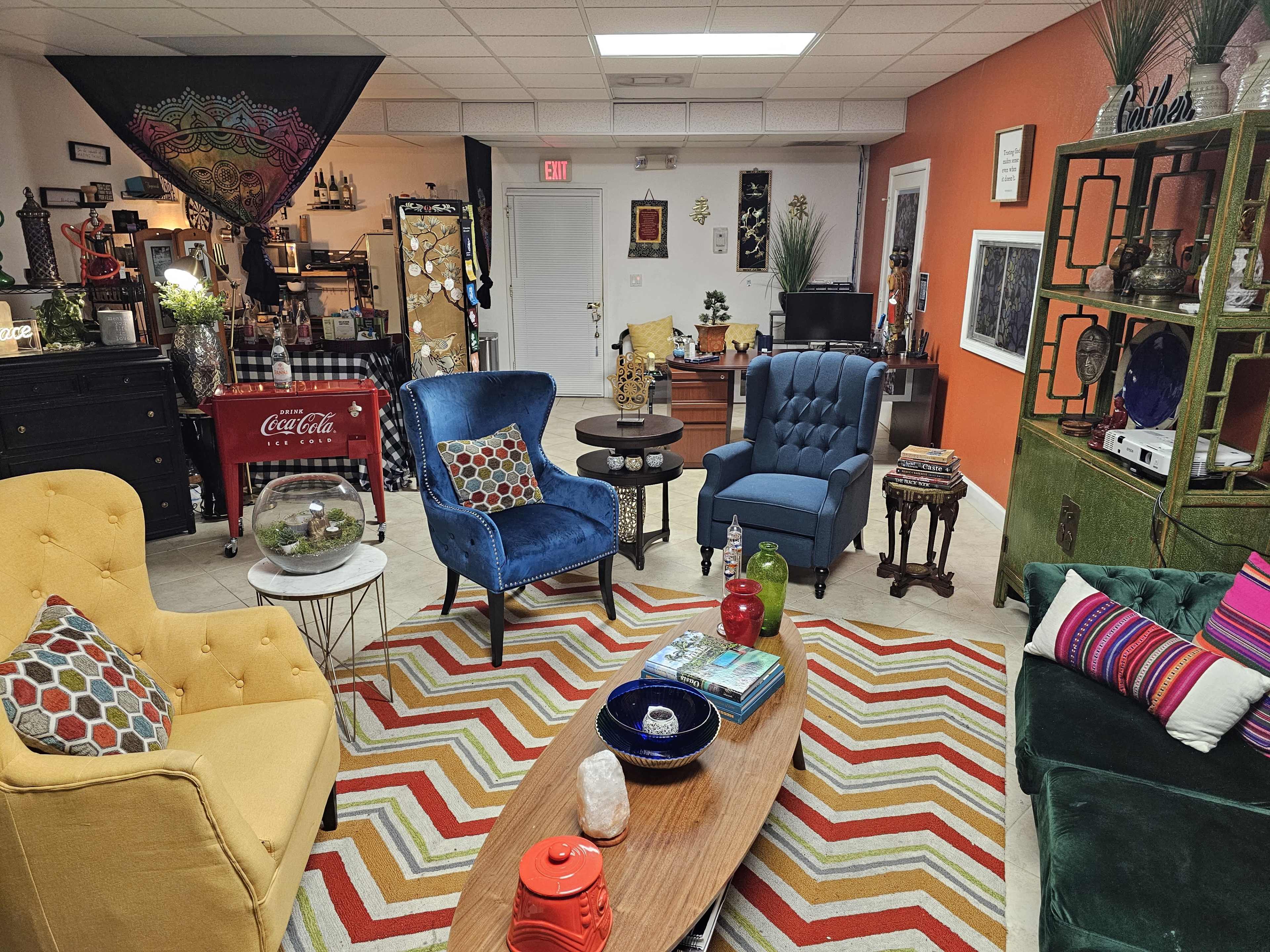 A decorated room with colorful seating arrangements, a patterned rug, and various decorative items on display.