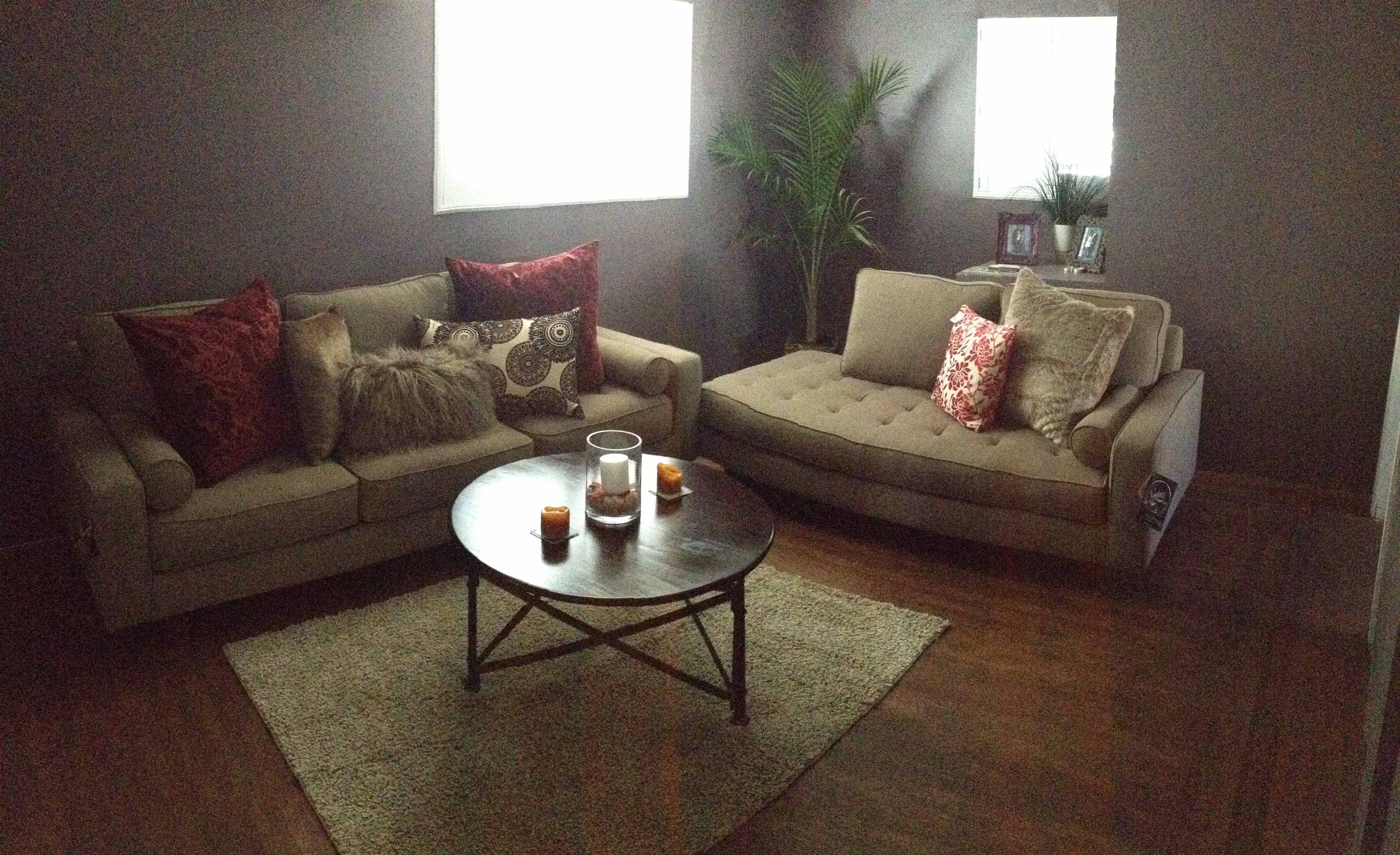 A living room with two sofas, a round coffee table, and a decorative rug.