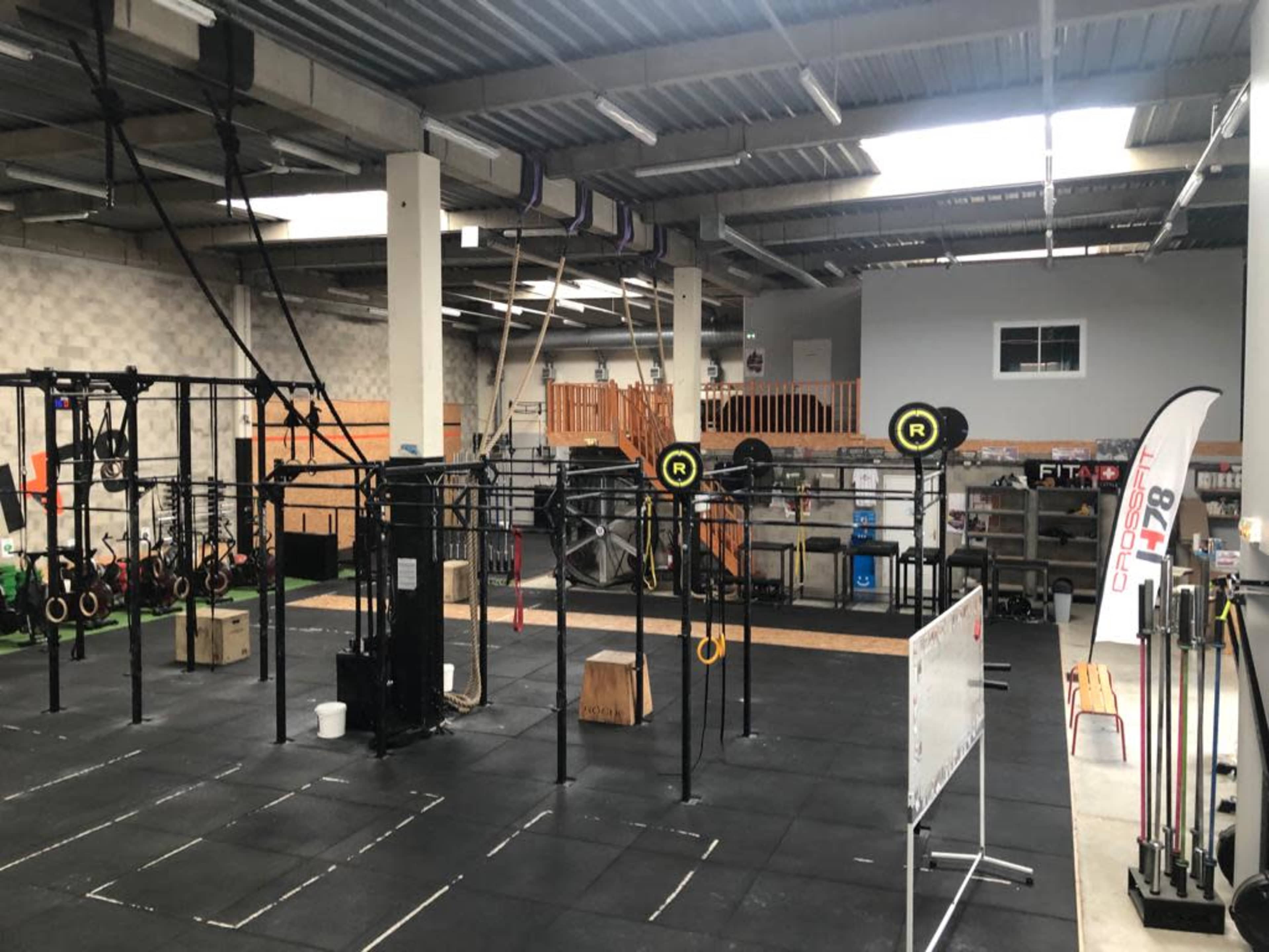 A spacious gym area equipped with various exercise stations, including weightlifting racks and fitness equipment.