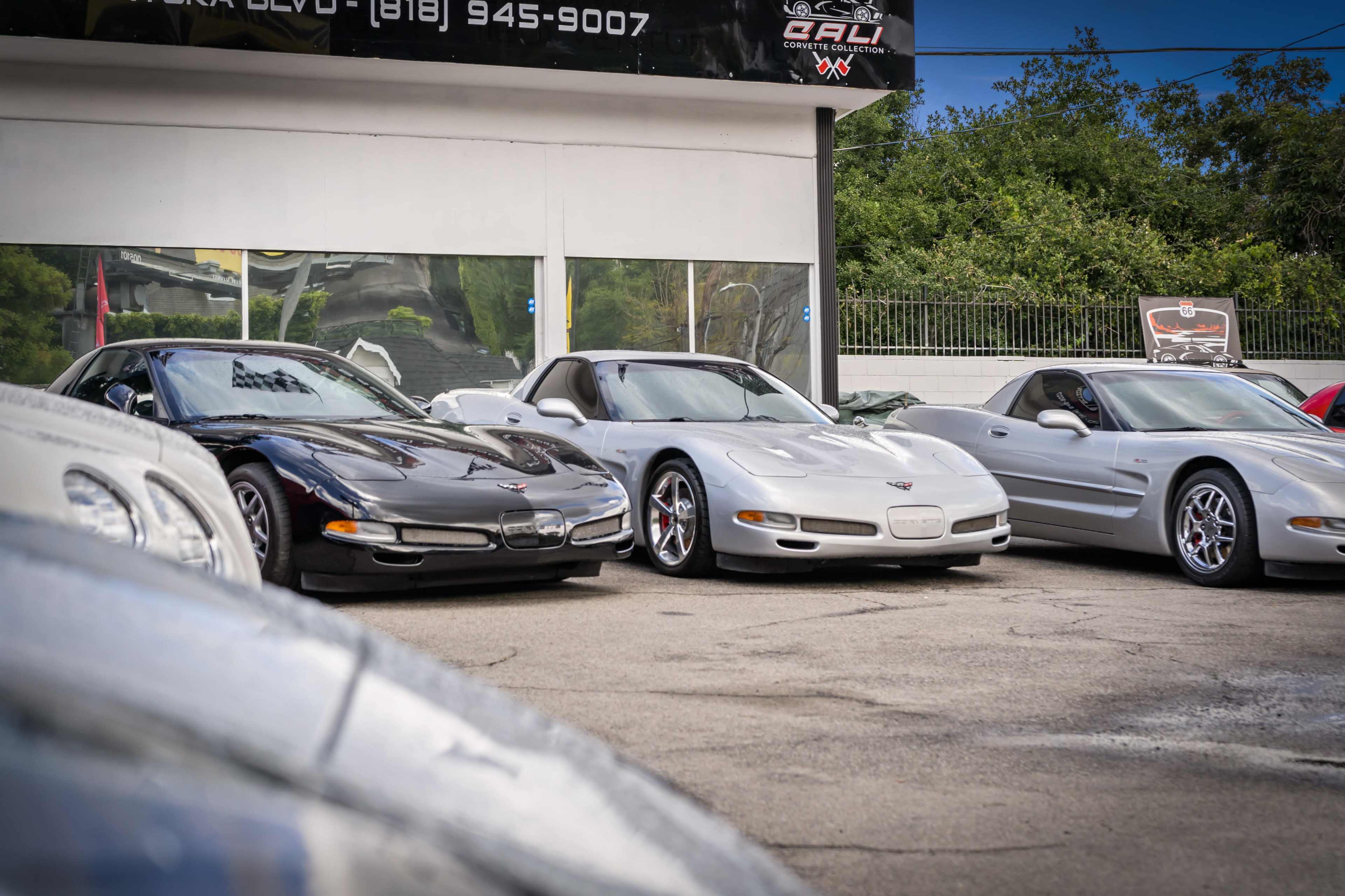 A lineup of three Chevrolet Corvette sports cars is displayed for sale at a car dealership.