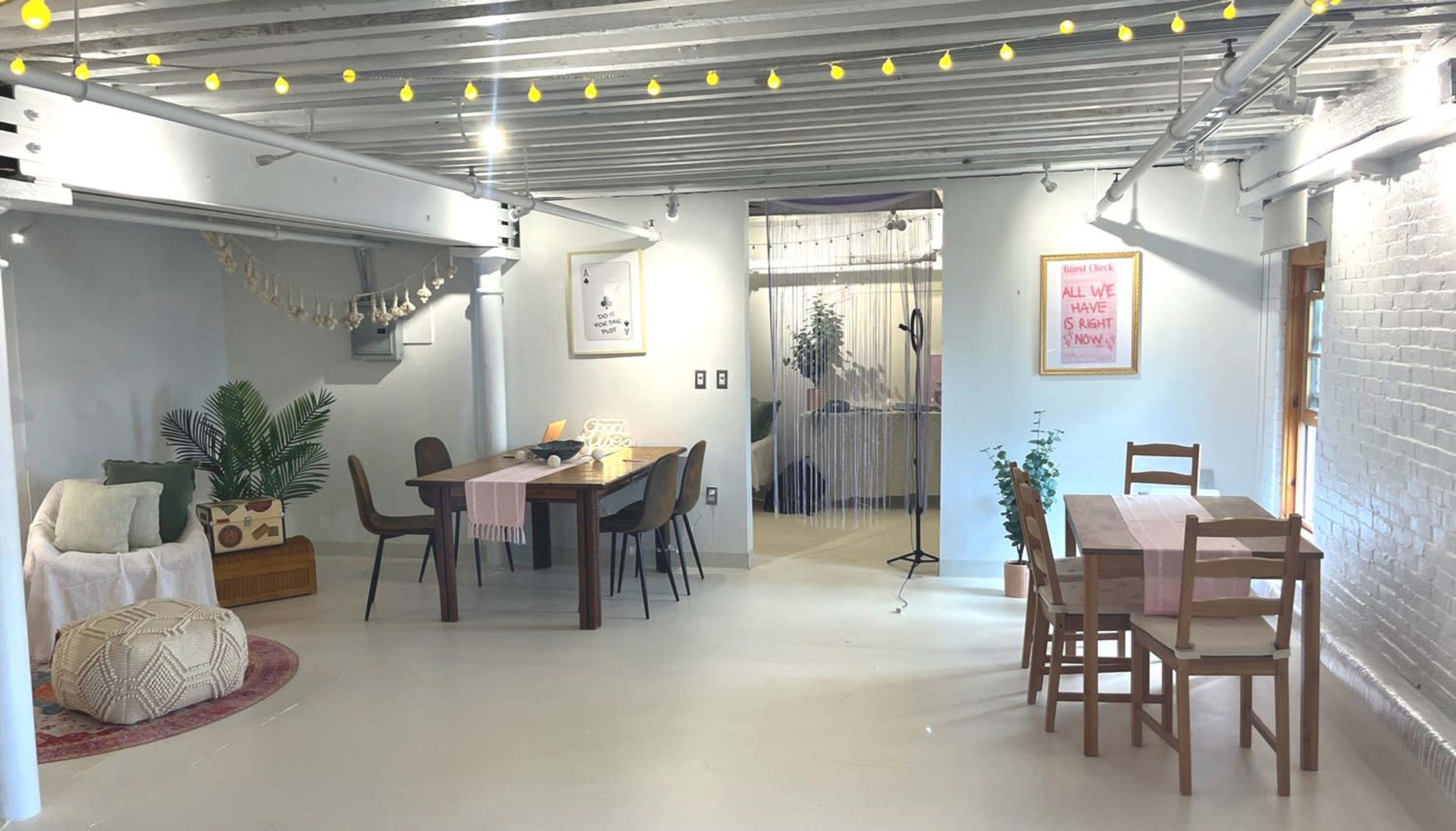 A spacious, modern interior featuring a dining area with tables and chairs, a cozy seating corner, and decorative plants.