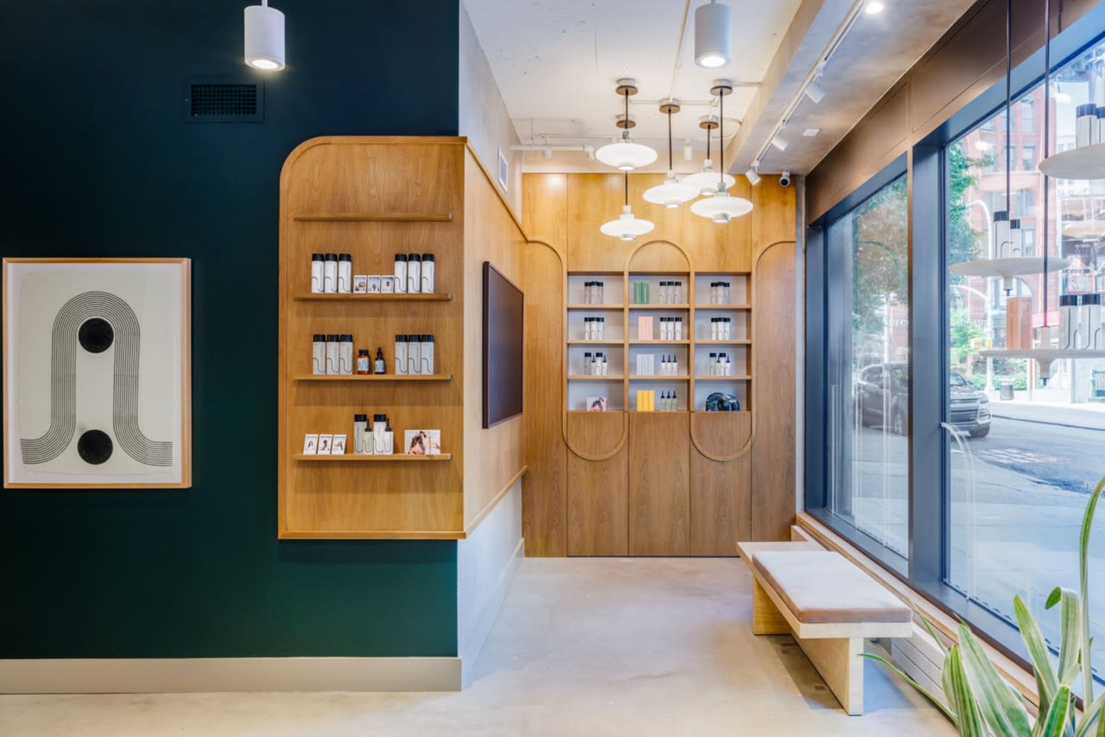 A modern interior of a skincare shop featuring wooden shelves with products, a large window, and pendant lights.