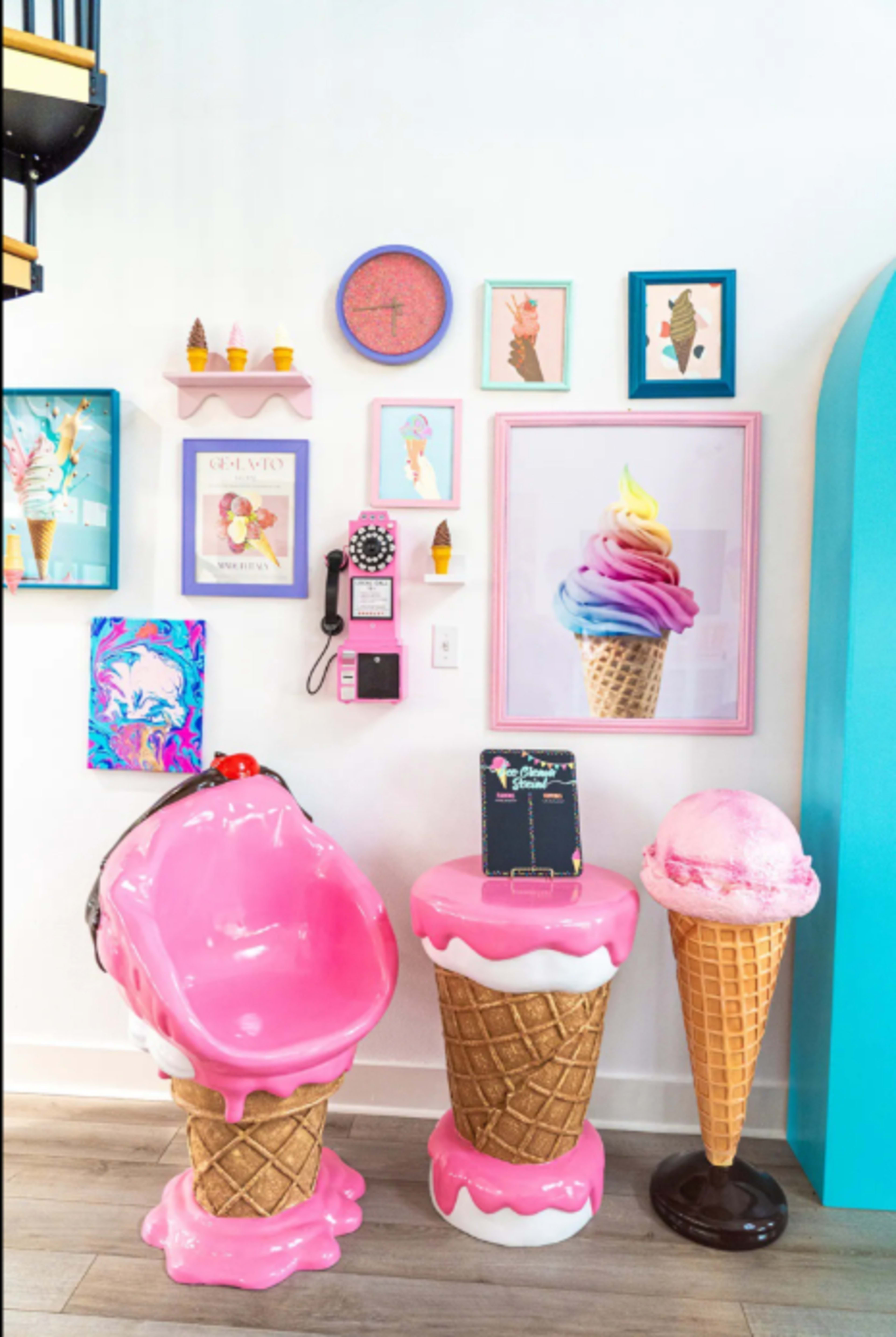 The scene features oversized, colorful ice cream-themed furniture, including a pink chair shaped like an ice cream cone and decorative wall art displaying various ice cream illustrations.