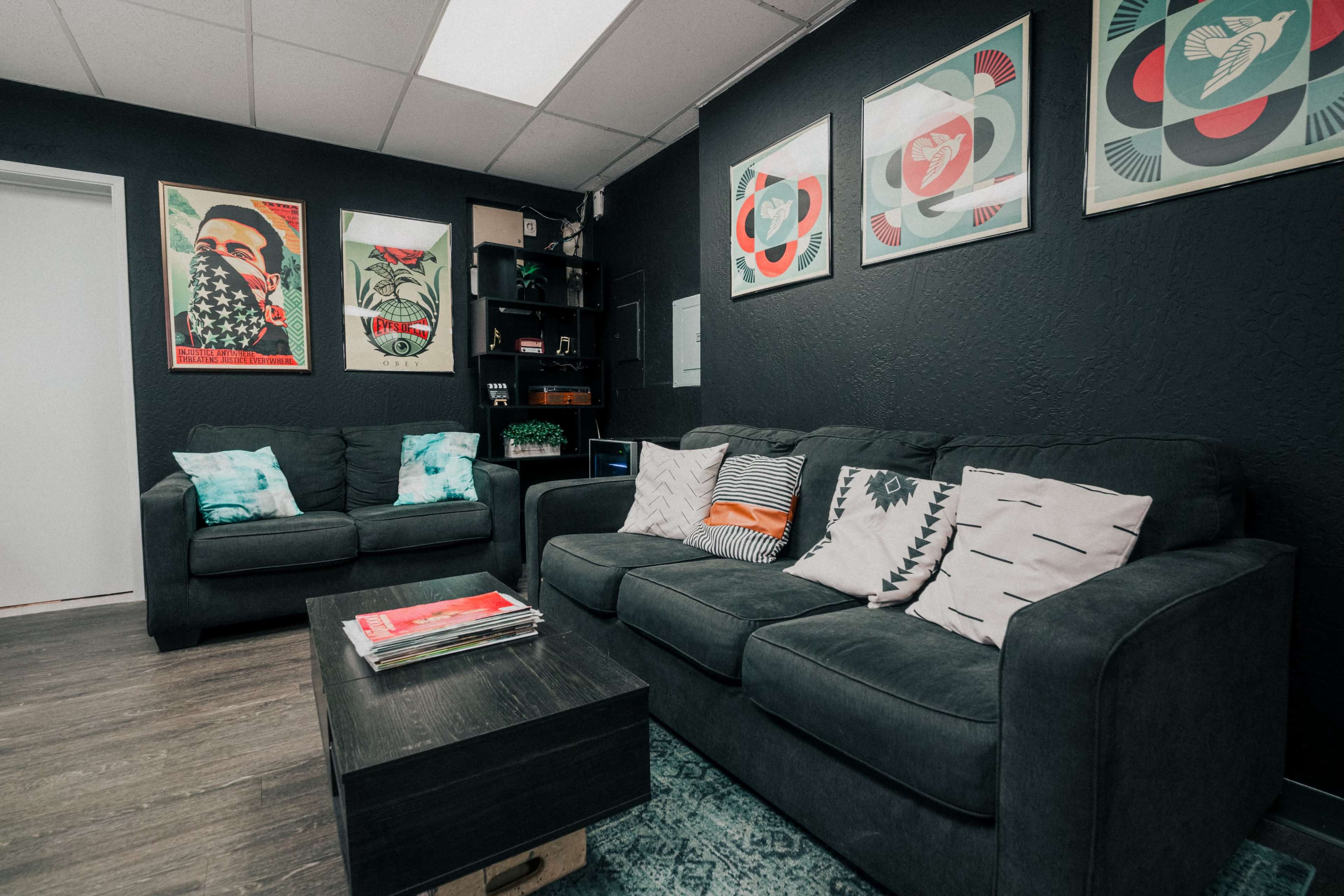 A modern lounge area with two sofas, a coffee table, and framed artwork on the walls.