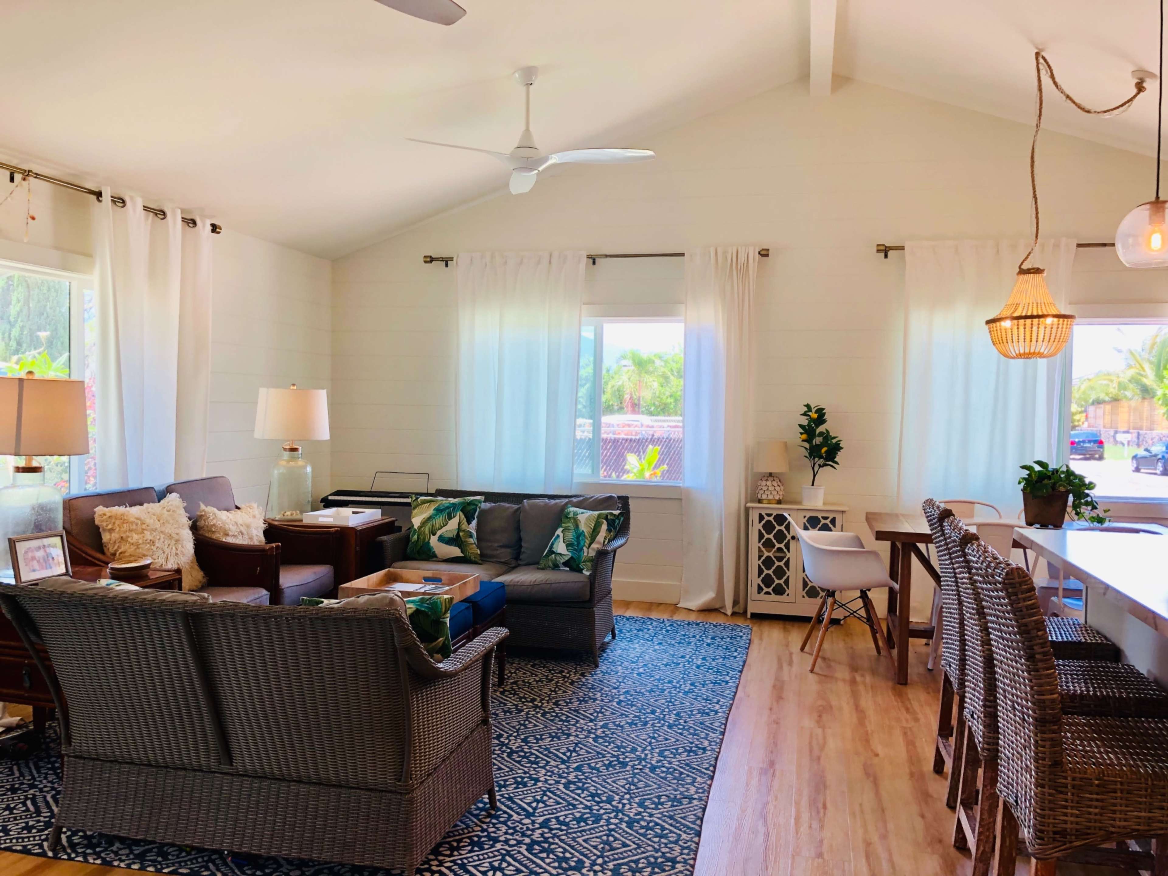 A bright living area with a mix of seating options, light-colored walls, and large windows allowing natural light to fill the space.