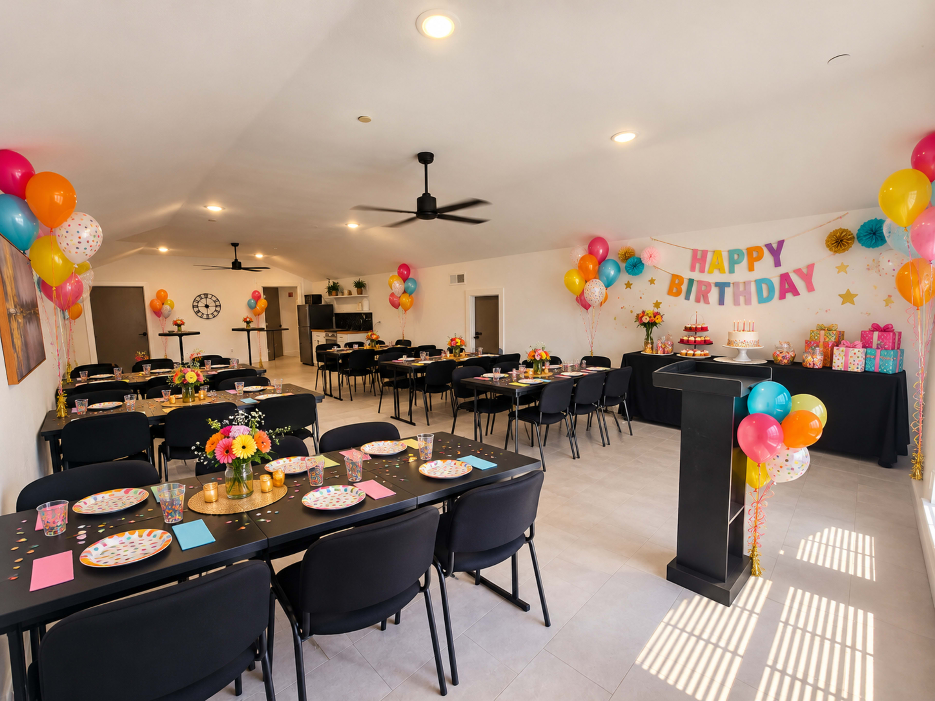 The image shows a decorated indoor party space set up for a birthday celebration, featuring multiple tables with colorful table settings, balloons, and a "Happy Birthday" banner.