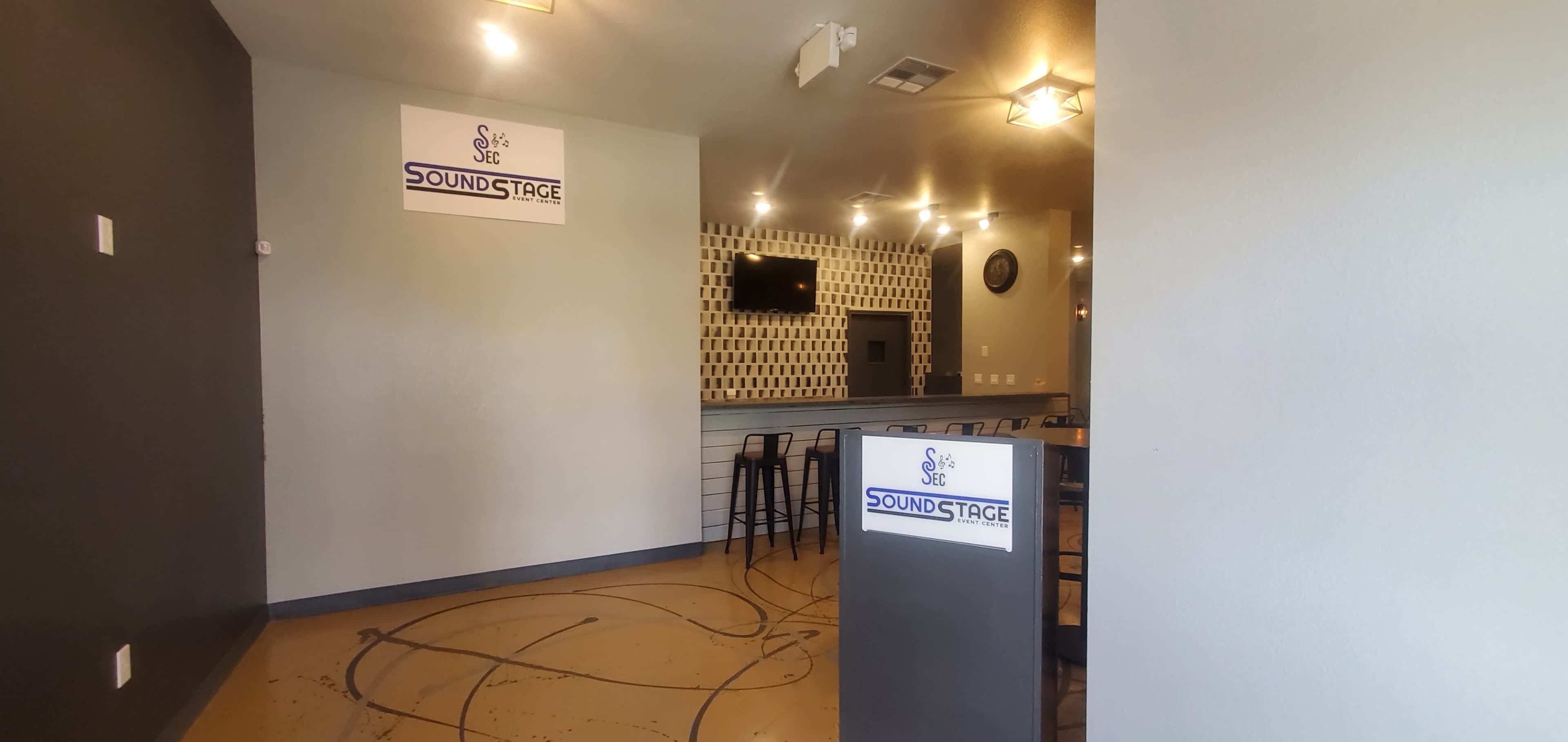 The interior of a venue named "Sound Stage," featuring a reception area with a front desk, a television on the wall, and a modern design.