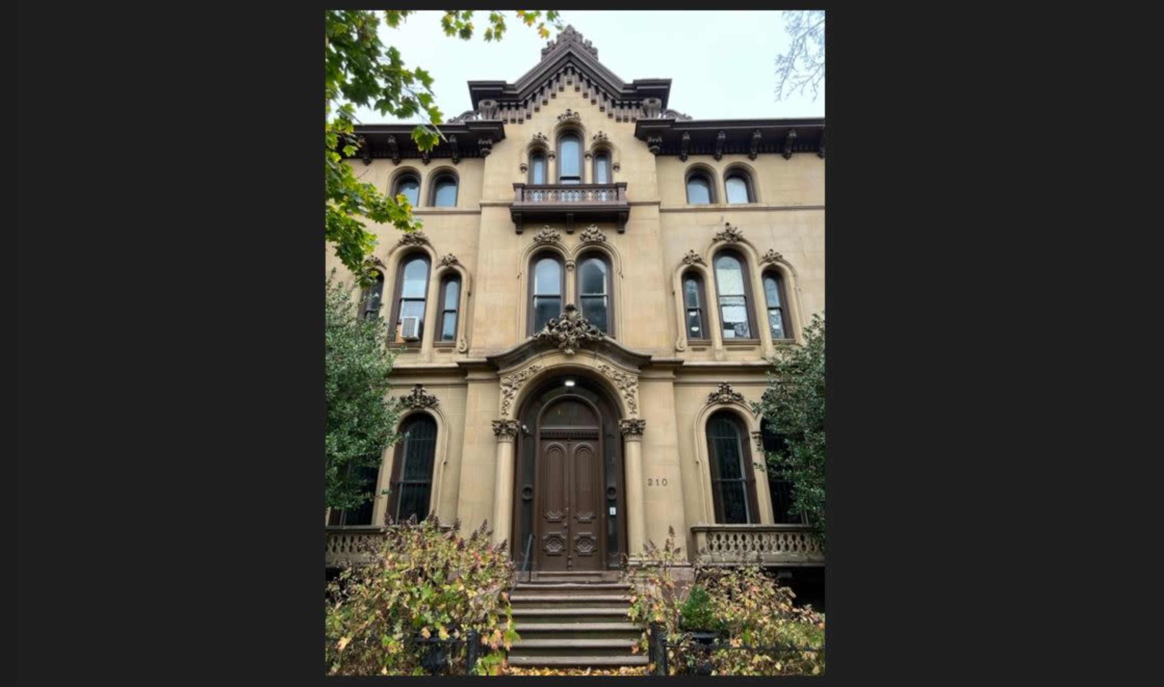 A large, ornate Victorian-style brownstone building with elaborate architectural details and a symmetrical facade.