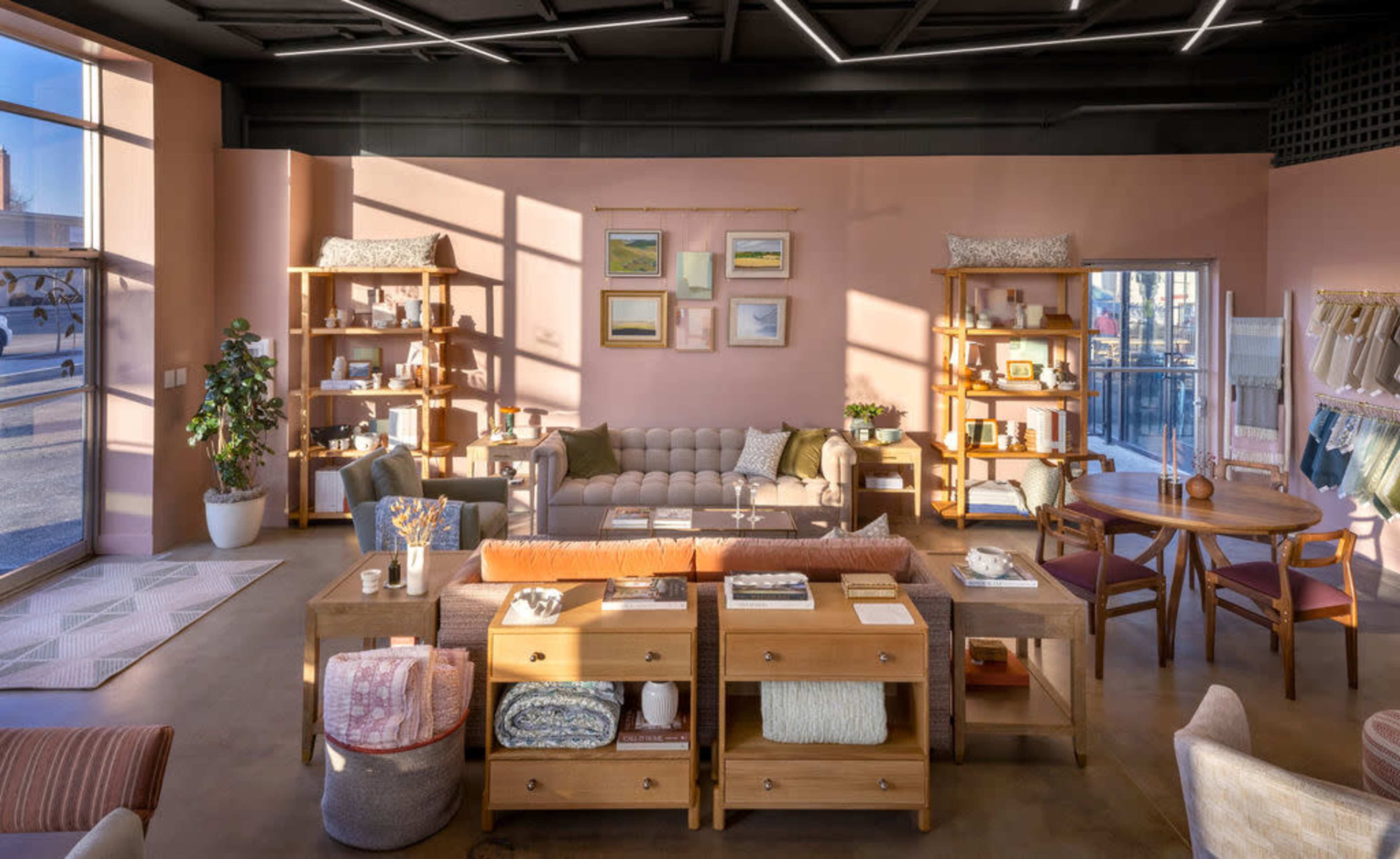 A well-organized interior of a home goods store, featuring furniture displays, shelving with decorative items, and a dining table arranged with various products.