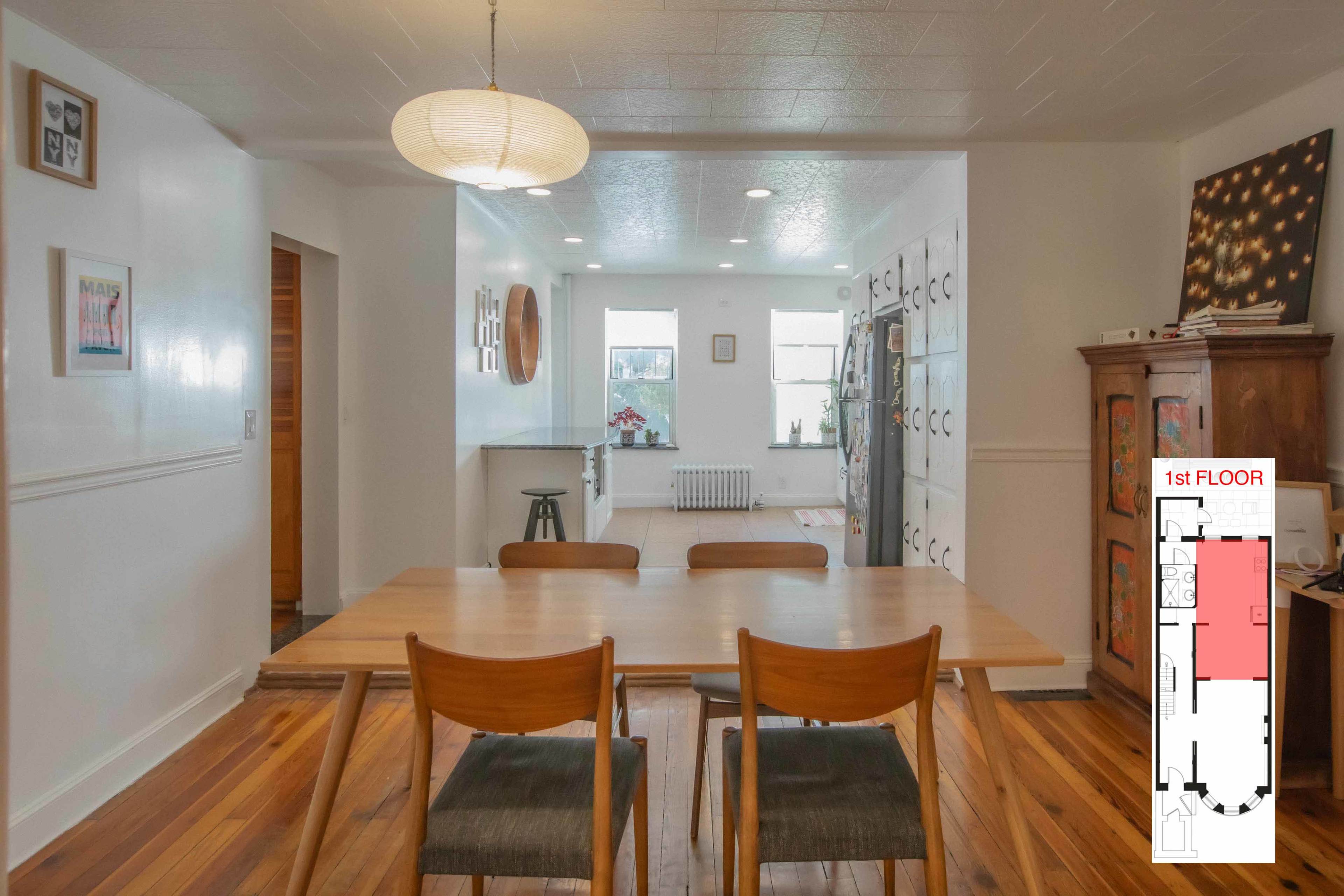A dining area with a wooden table and chairs, leading to a well-lit kitchen space, along with a floor plan inset.