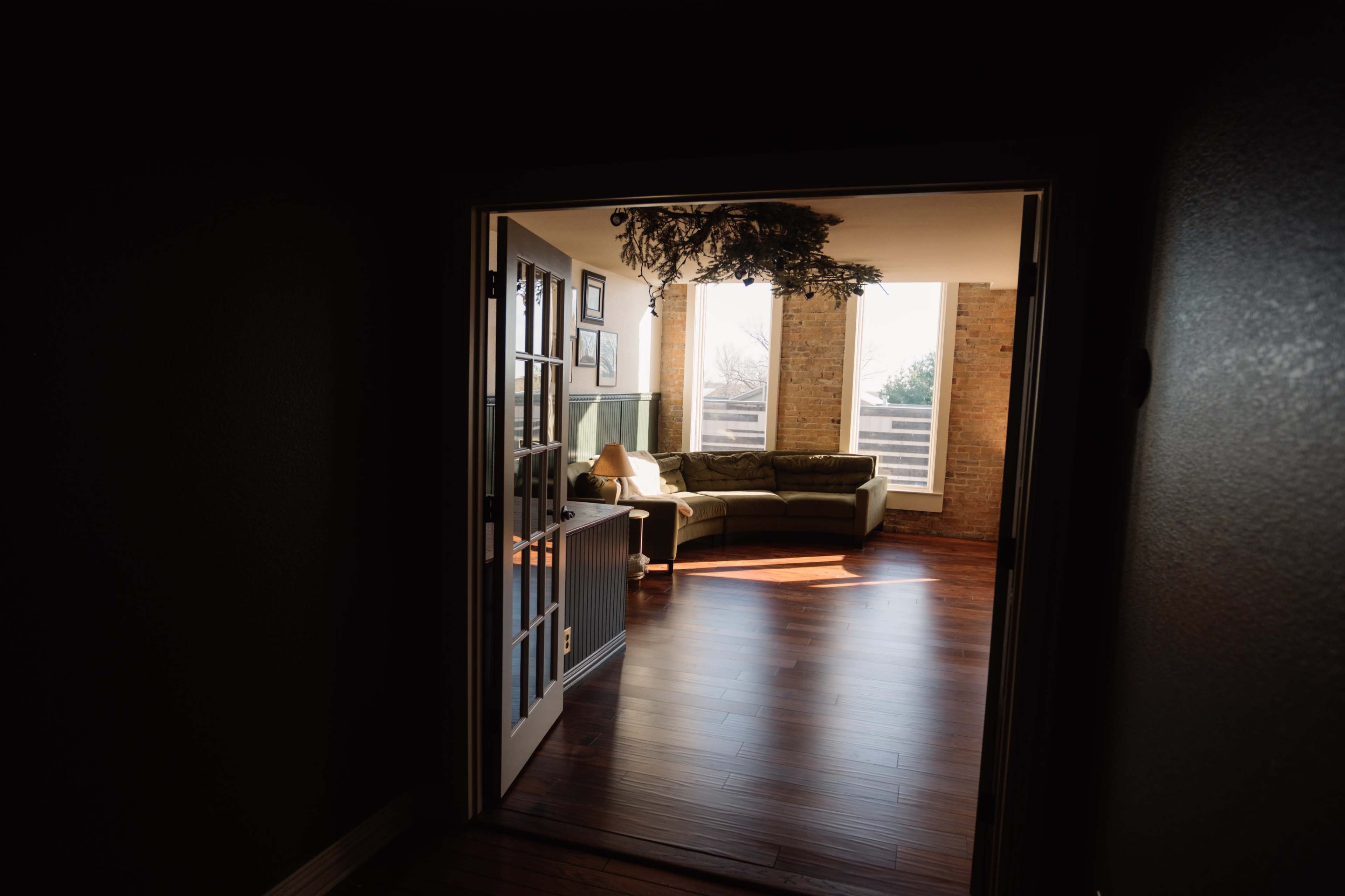 Mid-Century Modern European Inspired Living Room Loft - with exposed brick, large windows for natural light, and access to a full kitchen & bathroom Image in Denton, Denton, TX