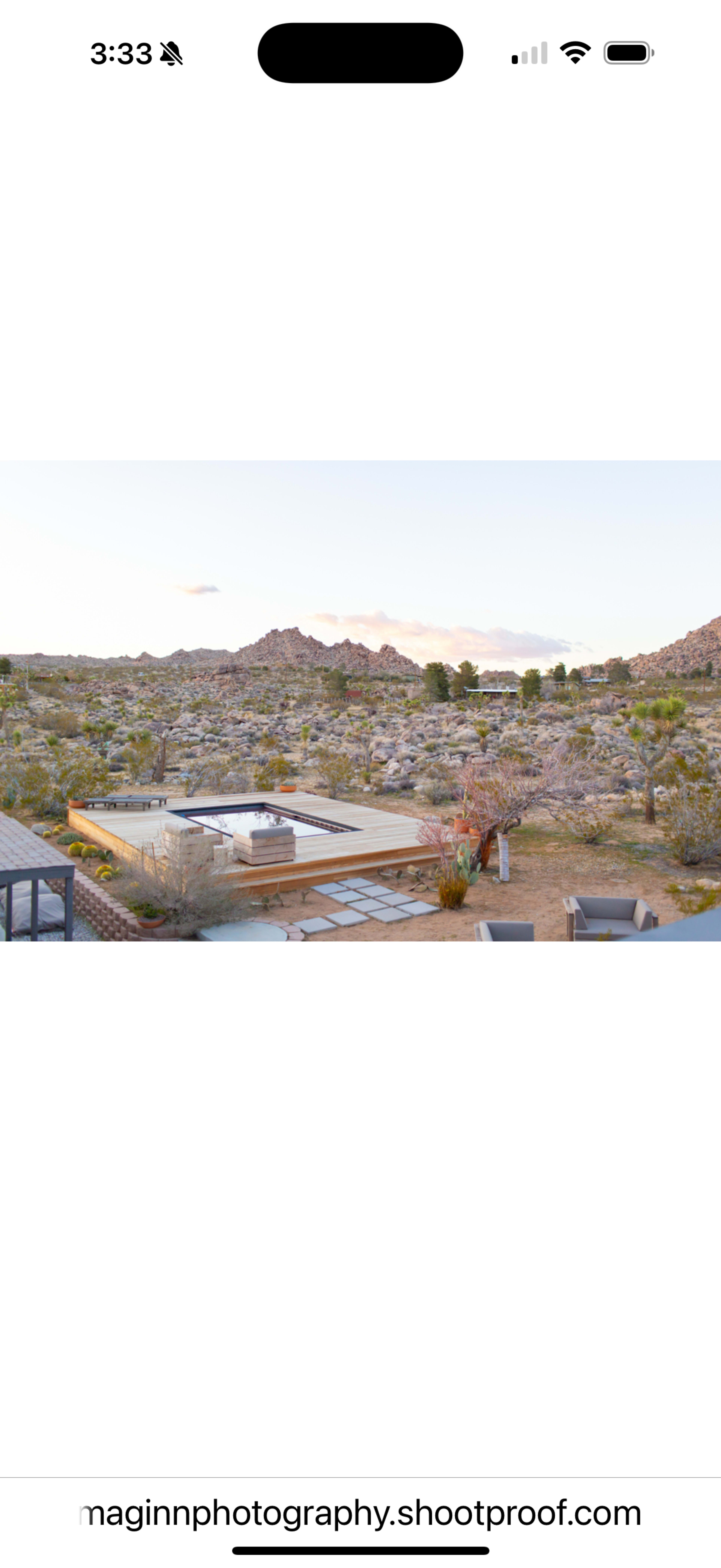The image shows a modern outdoor deck with a swimming pool in a desert landscape featuring rocky hills and sparse vegetation.