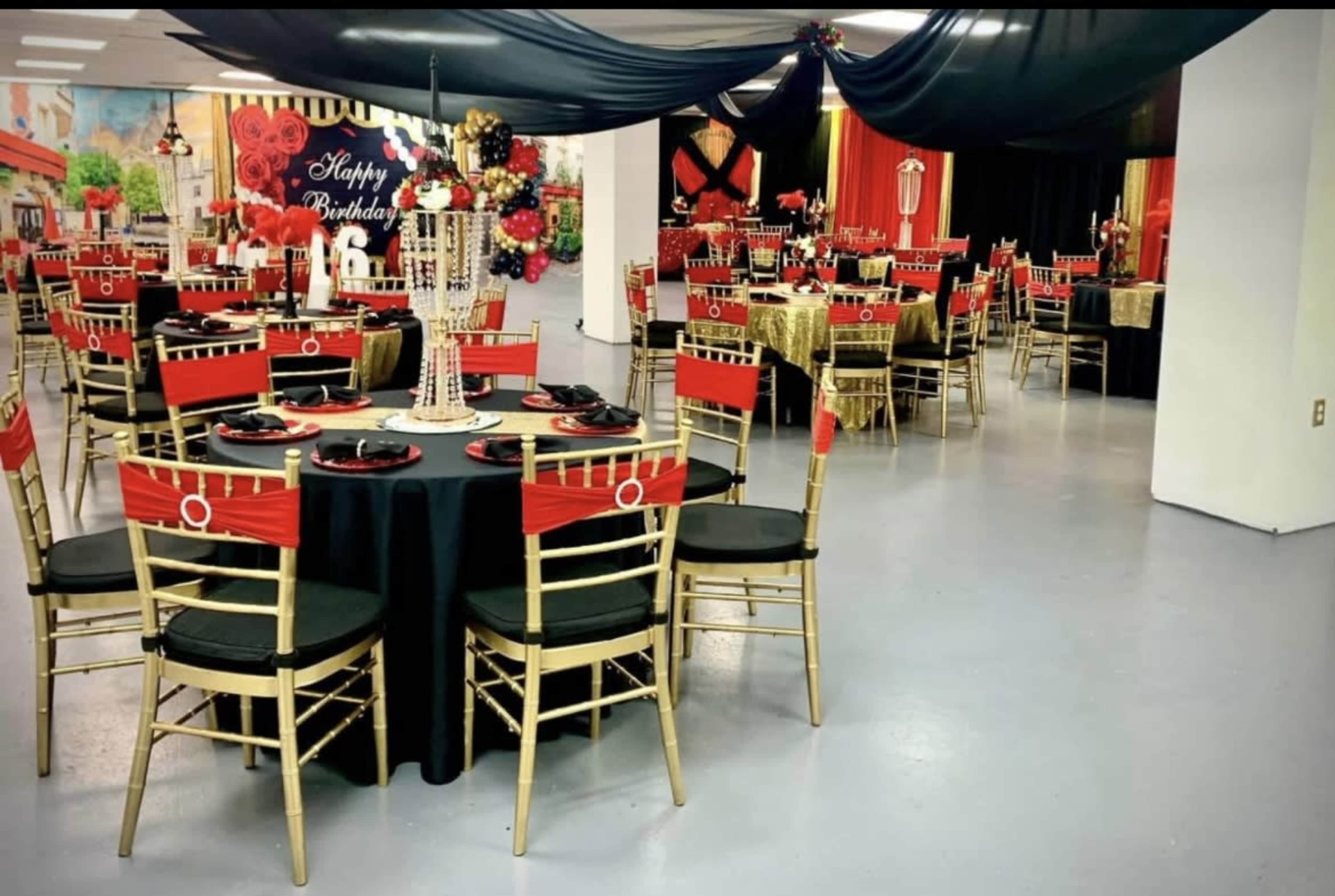 The image shows a decorated event space with black and gold tables and chairs, set up for a birthday celebration.