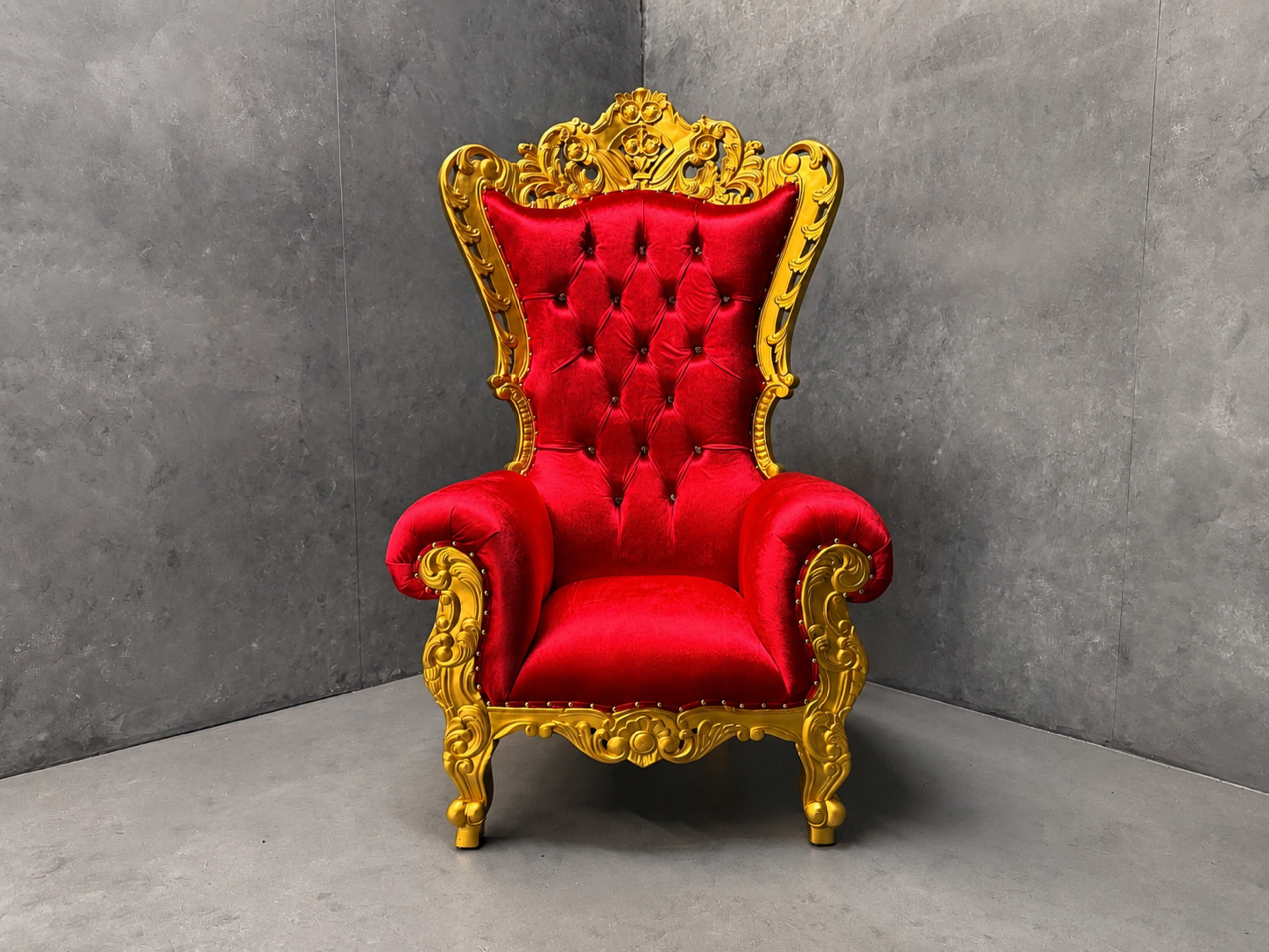 The image shows an ornate red and gold armchair with a high back and decorative carvings.