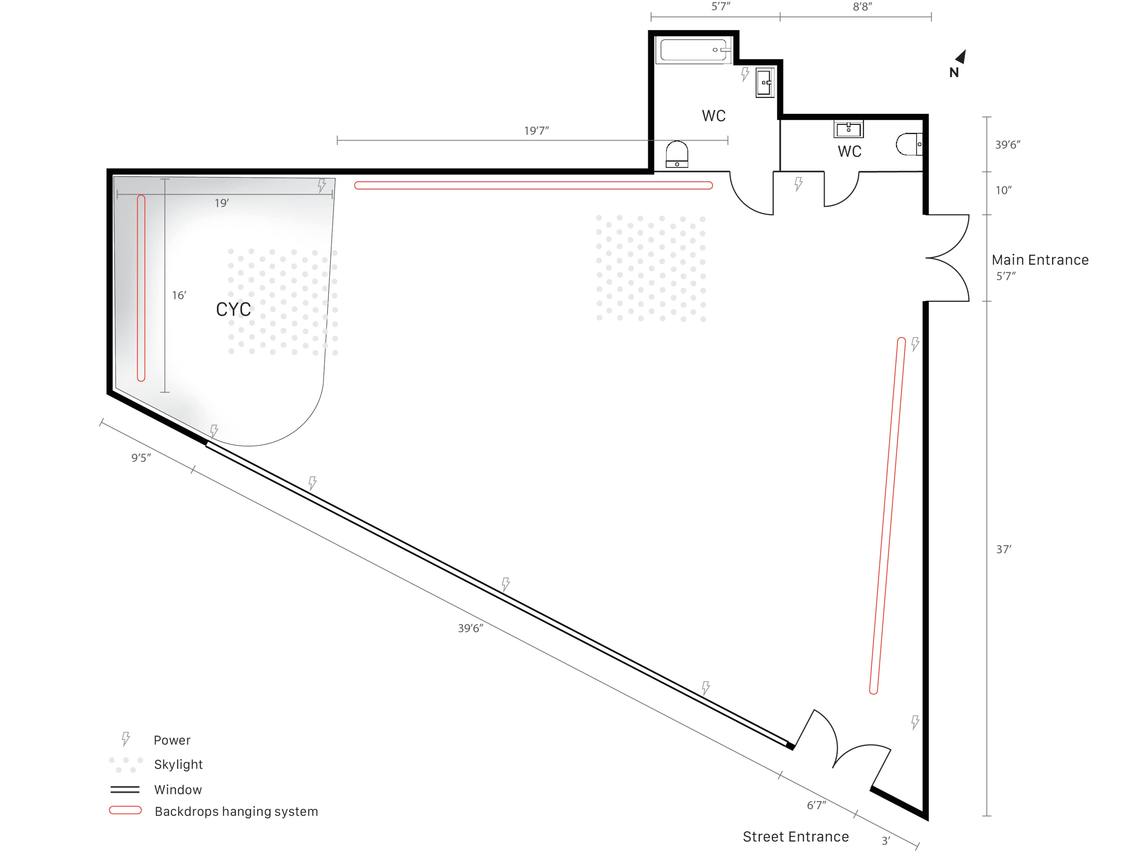 The image depicts a floor plan of a space with designated areas labeled for a cyc wall, entrances, windows, skylights, and two restrooms marked with their dimensions.