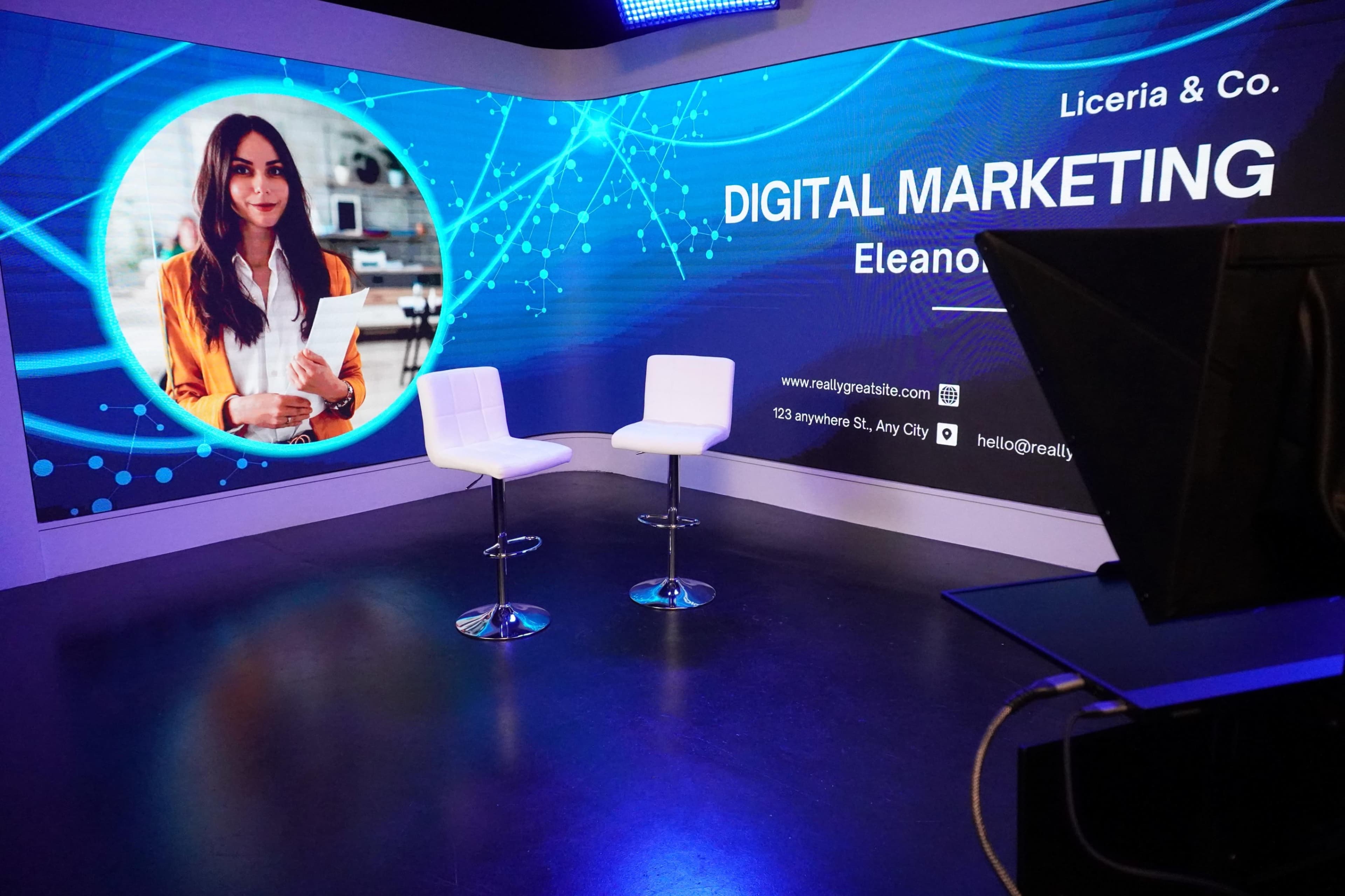 The image shows a modern studio set-up for a digital marketing presentation, featuring two white chairs and a large screen displaying the name "Eleanor" alongside a circular photo.