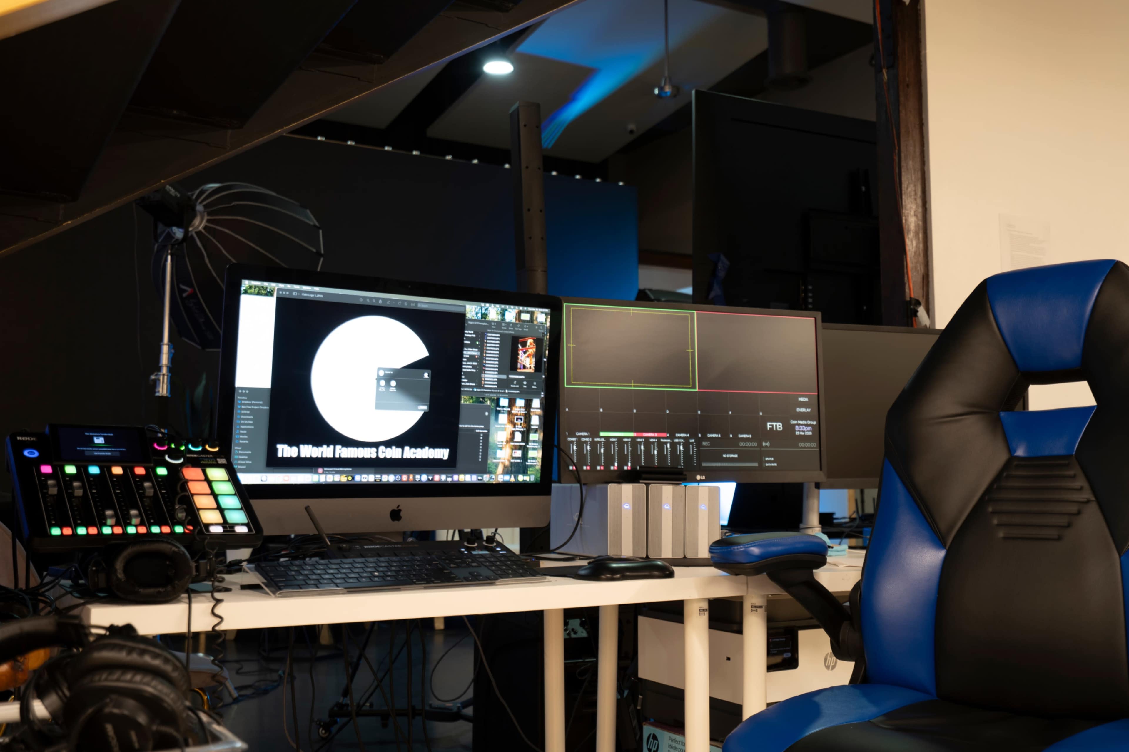 A modern workspace features a dual-monitor setup with a computer, control panel, and a gaming chair in an organized environment.