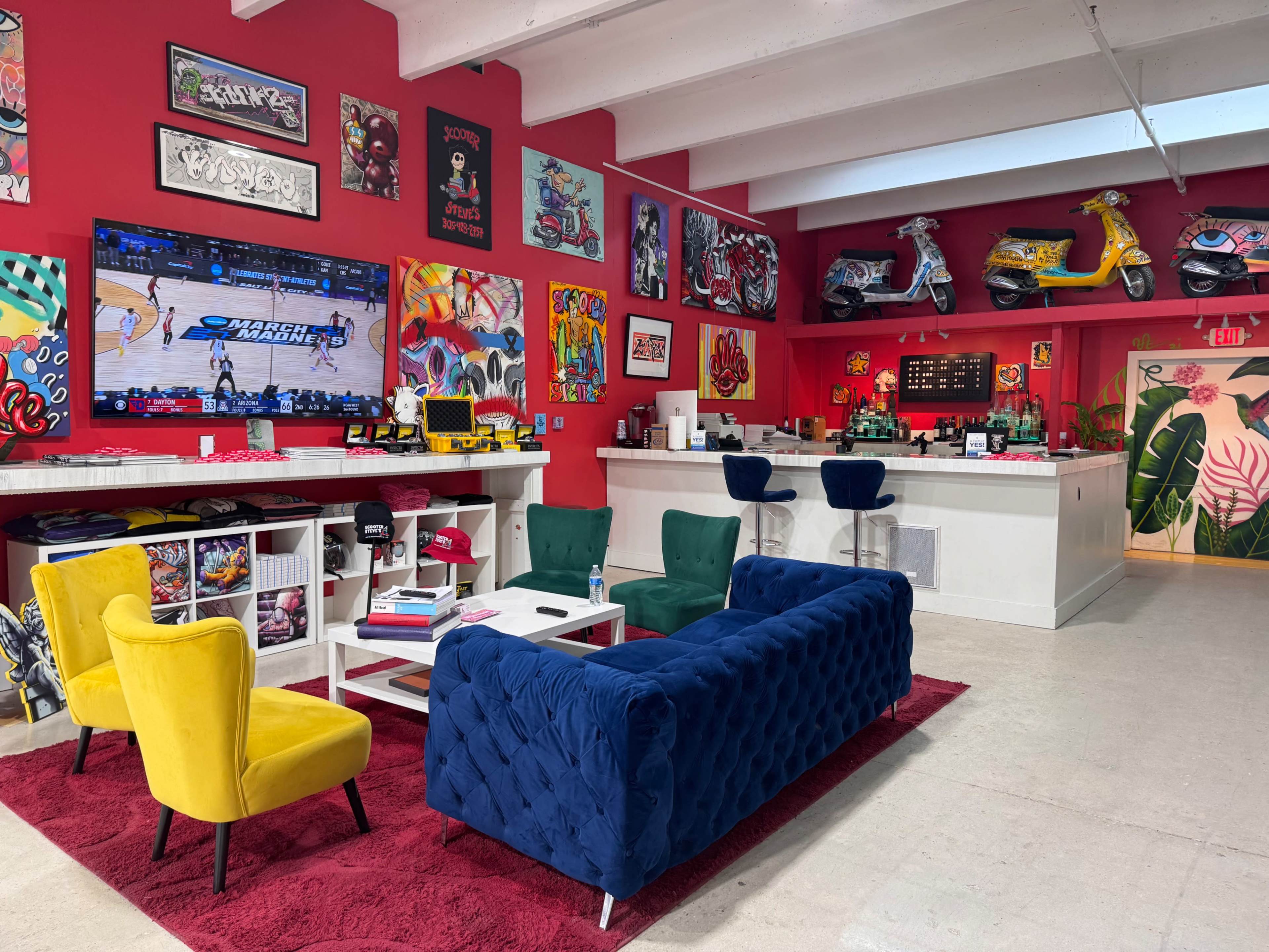 The scene features a vibrant lounge area with colorful armchairs and a blue velvet sofa, a large television displaying a basketball game, and walls adorned with various artworks and decorations.