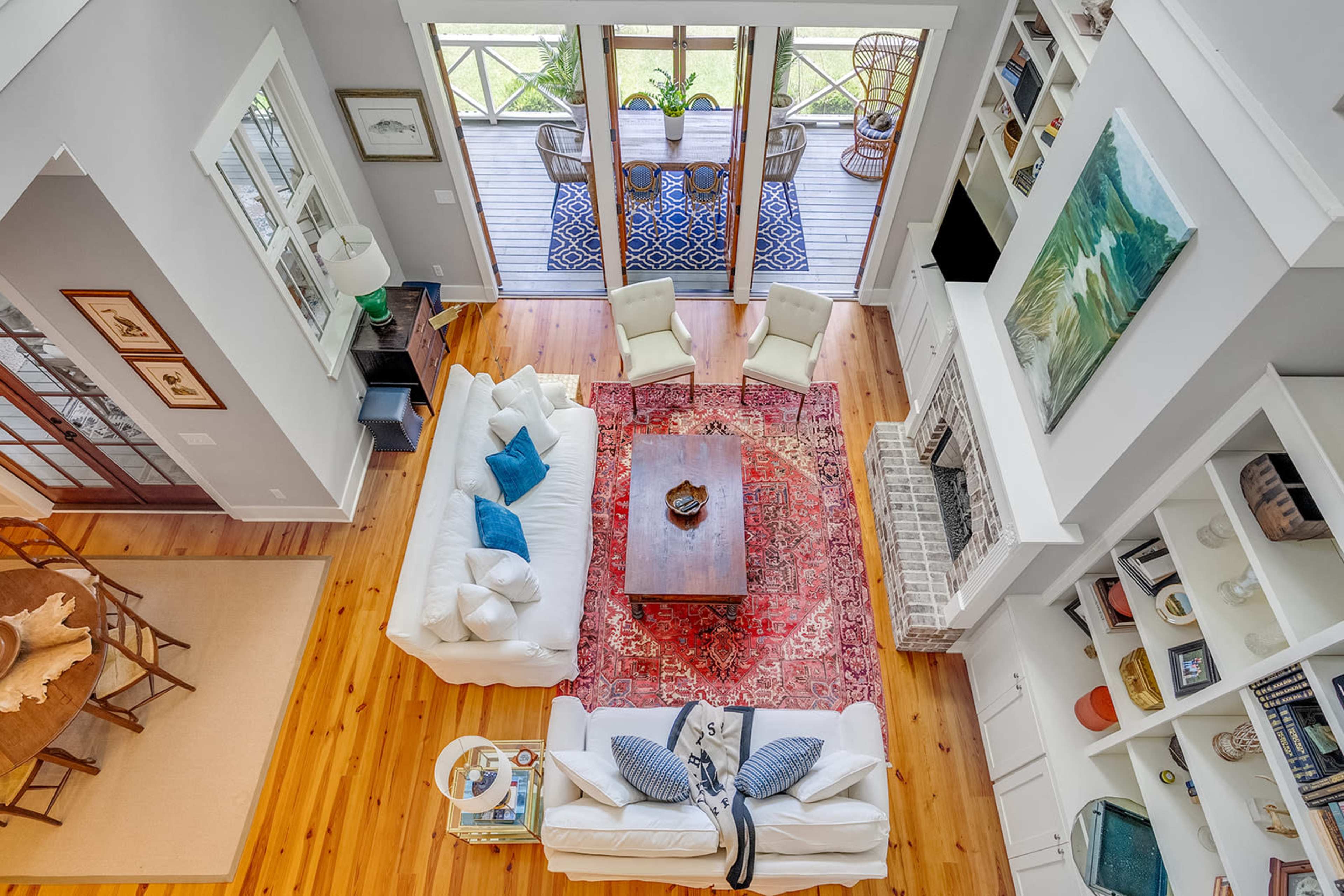 An open-concept living area features a seating arrangement around a coffee table, with a view of a deck through sliding glass doors.