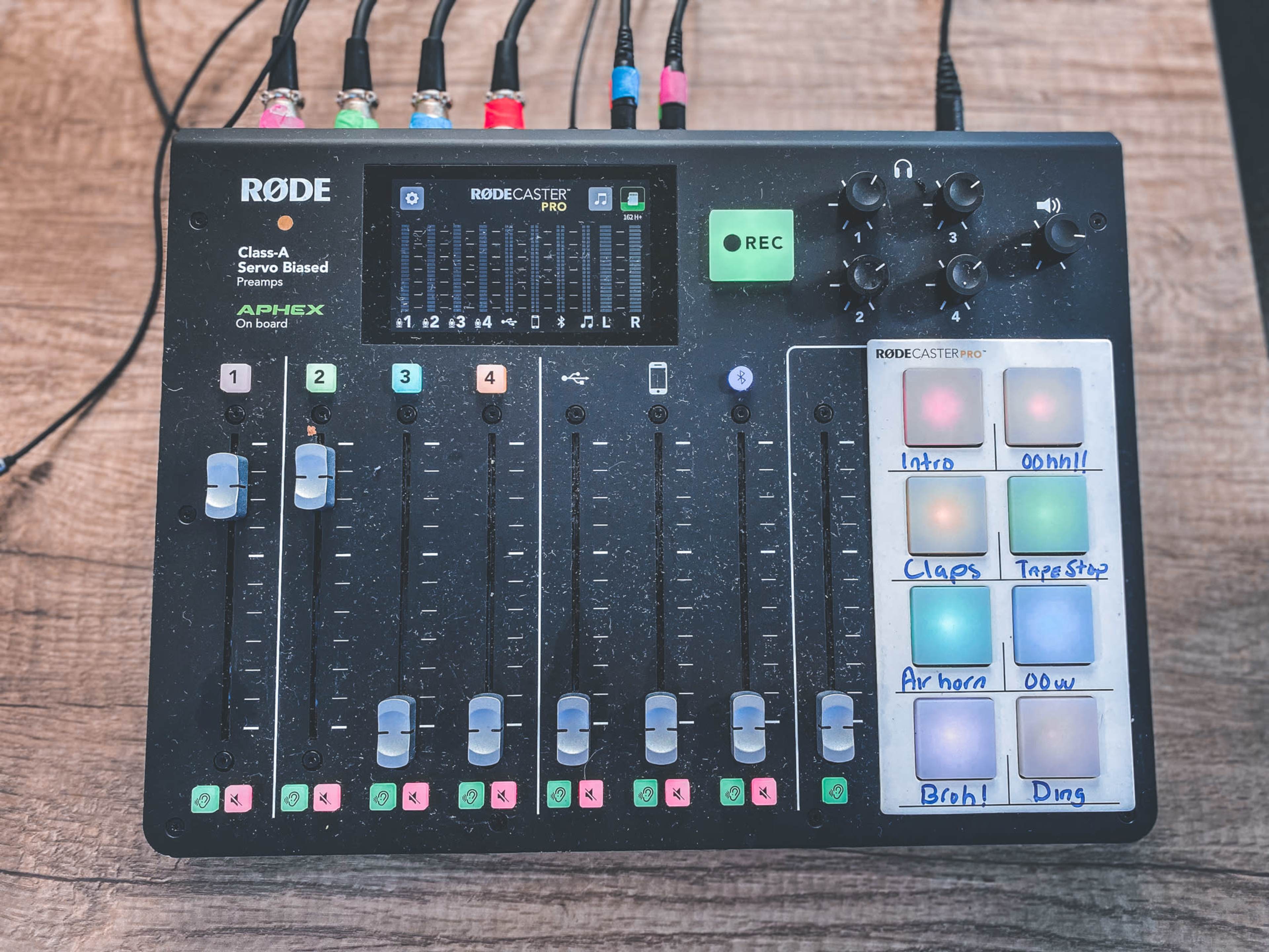 The image shows a Rodecaster Pro audio interface with multiple faders, buttons, and recording controls.