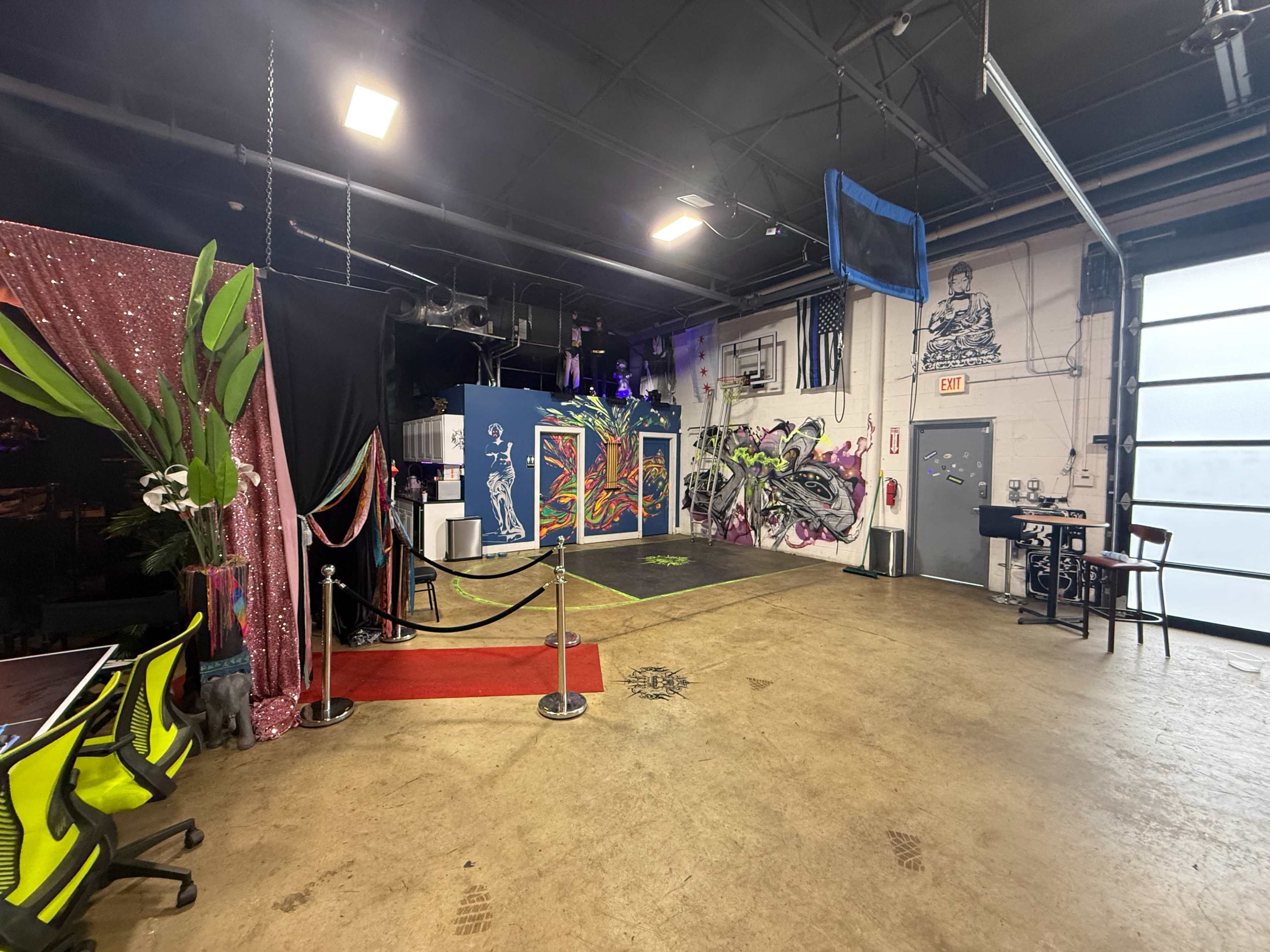 The scene features a brightly colored interior space with graffiti art on the walls, a red carpet, and a seating area with a bar at the back.