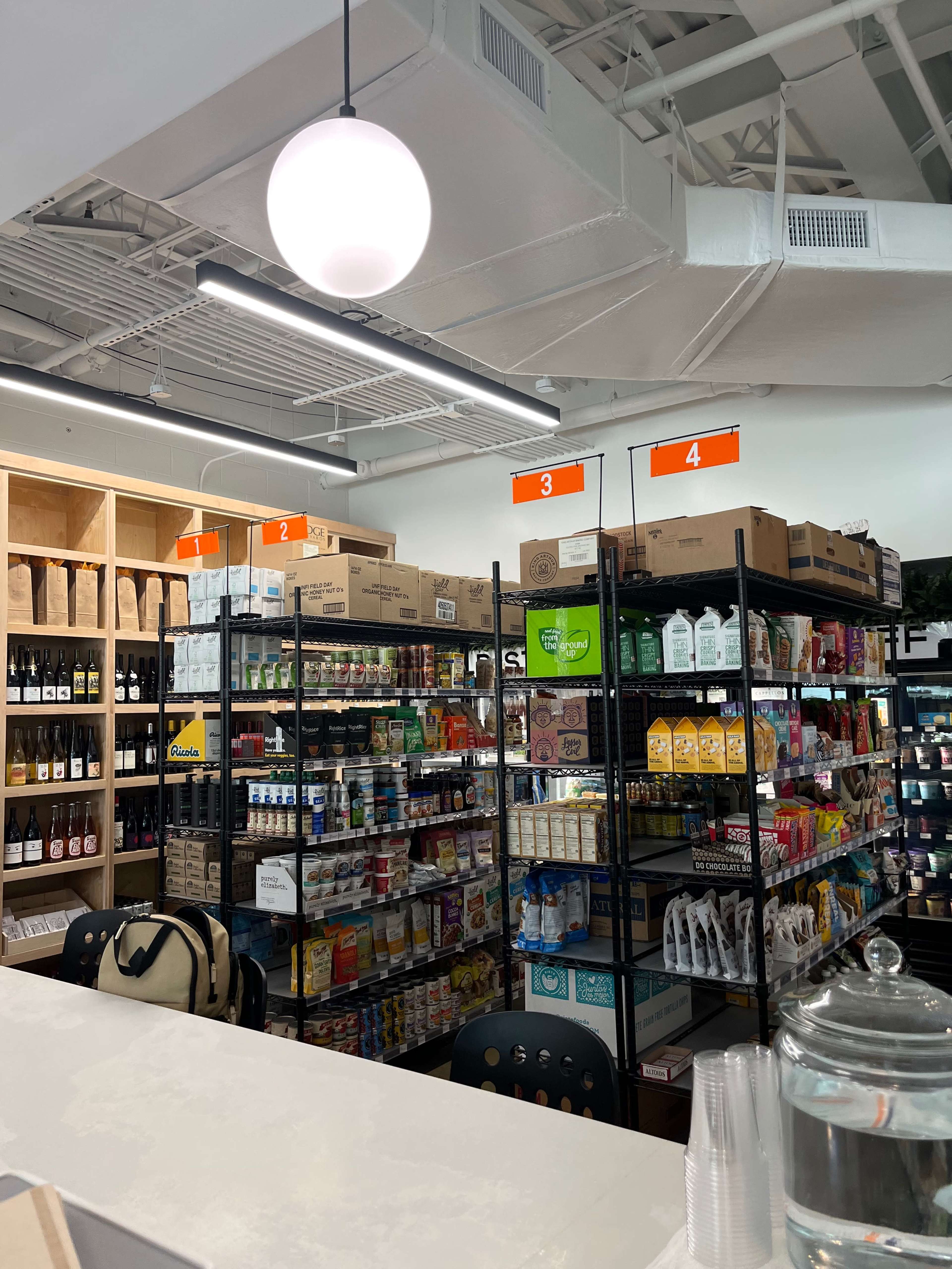 An interior of a retail store with shelves filled with various packaged food items and beverages, and a counter in the foreground.