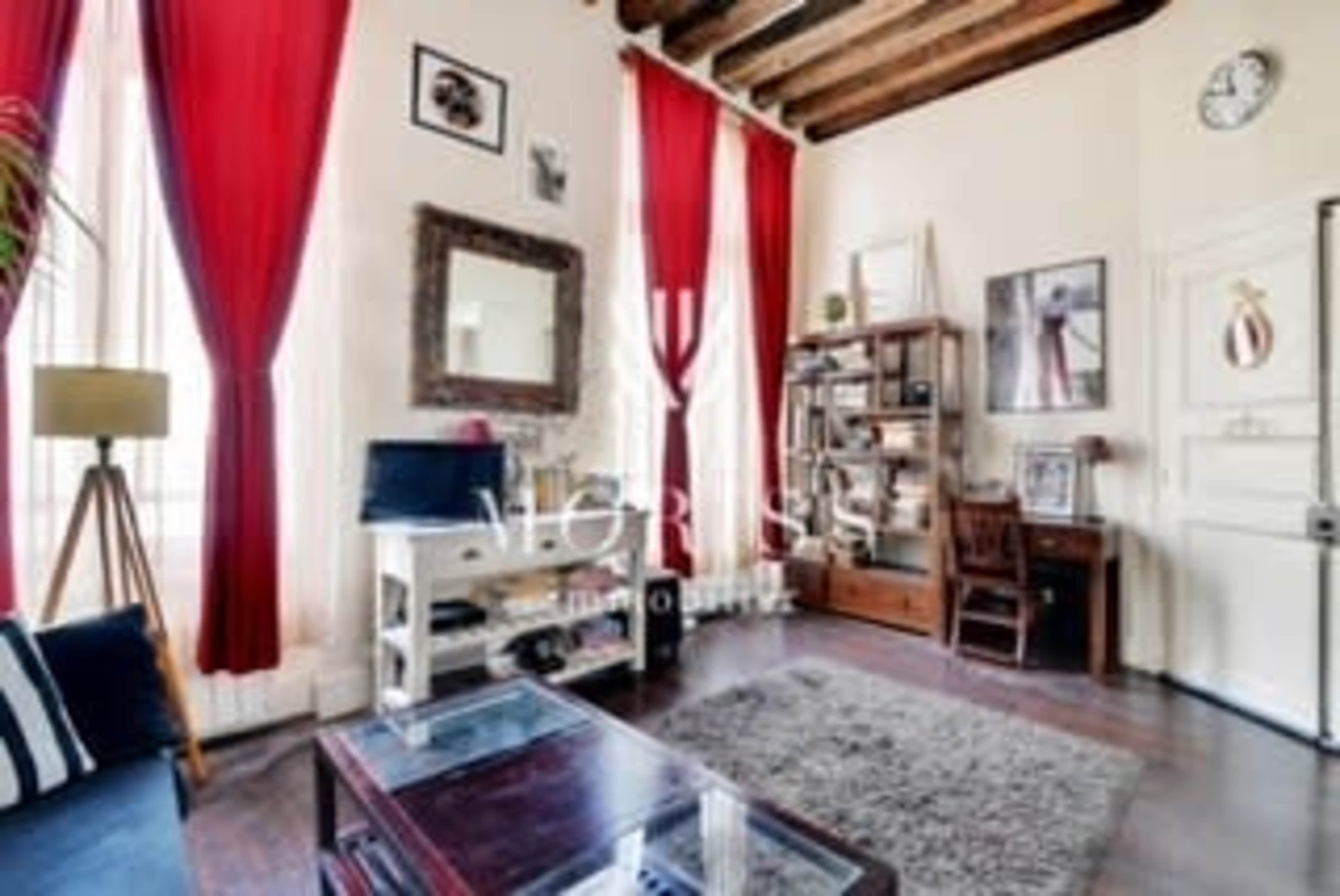 The image depicts a cozy living room featuring red curtains, a wooden bookshelf, and a clock on the wall.