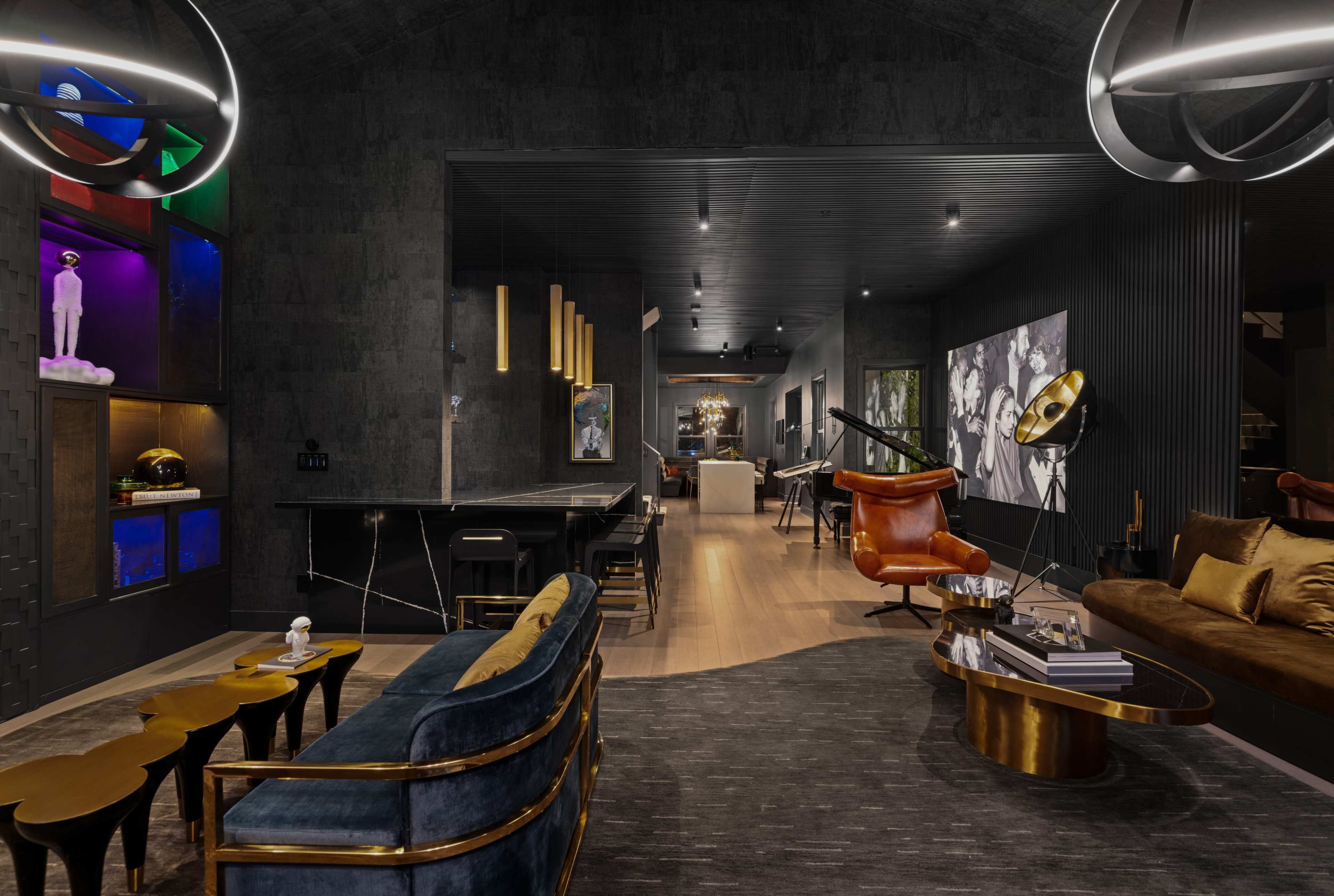 A modern interior space featuring a stylish lounge area with a mix of furniture, including a velvet sofa, armchair, and a sleek bar counter.