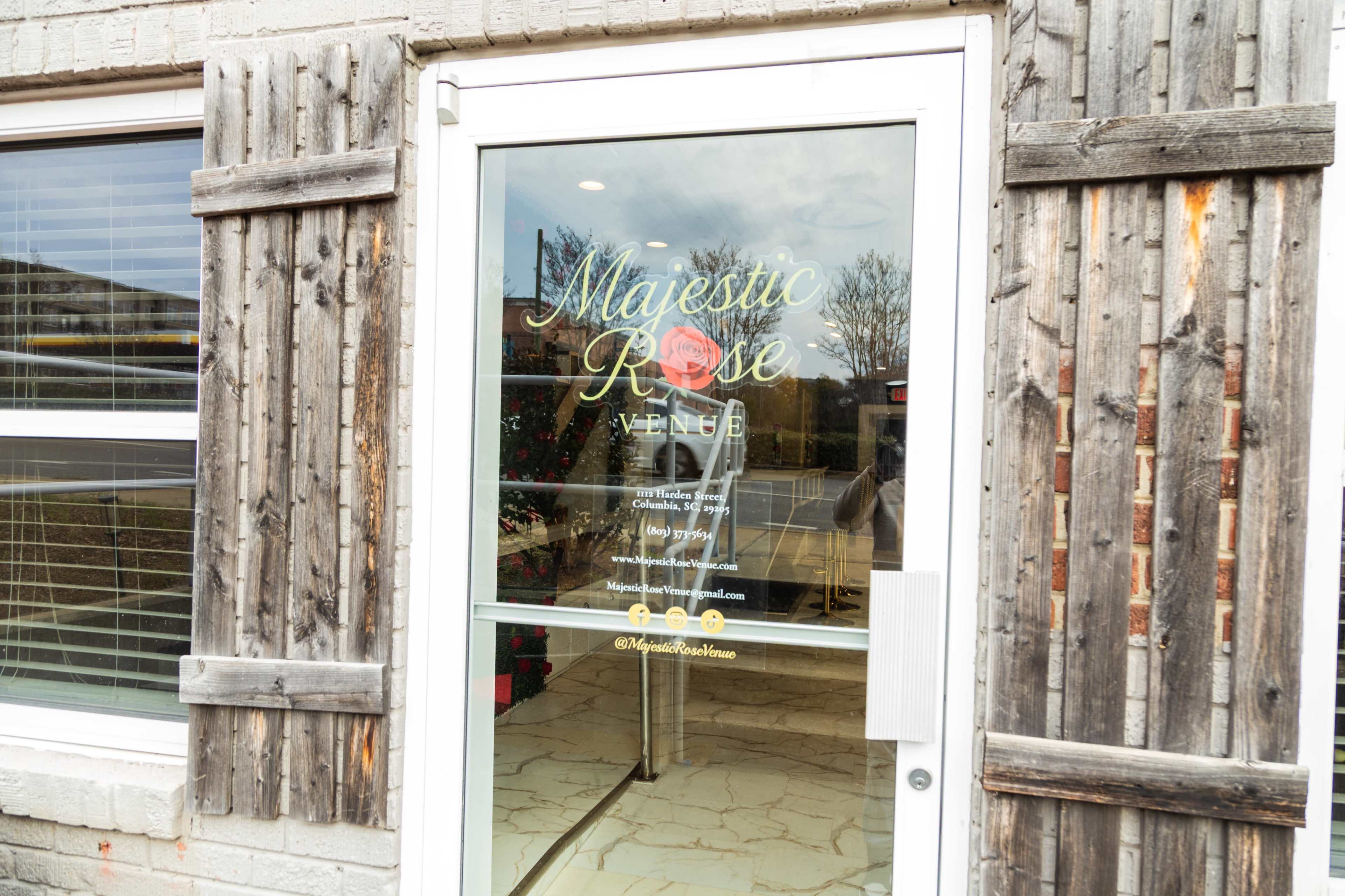 The entrance of the Majestic Rose venue features a glass door with decorative wooden shutters and a prominent sign with the venue's name.