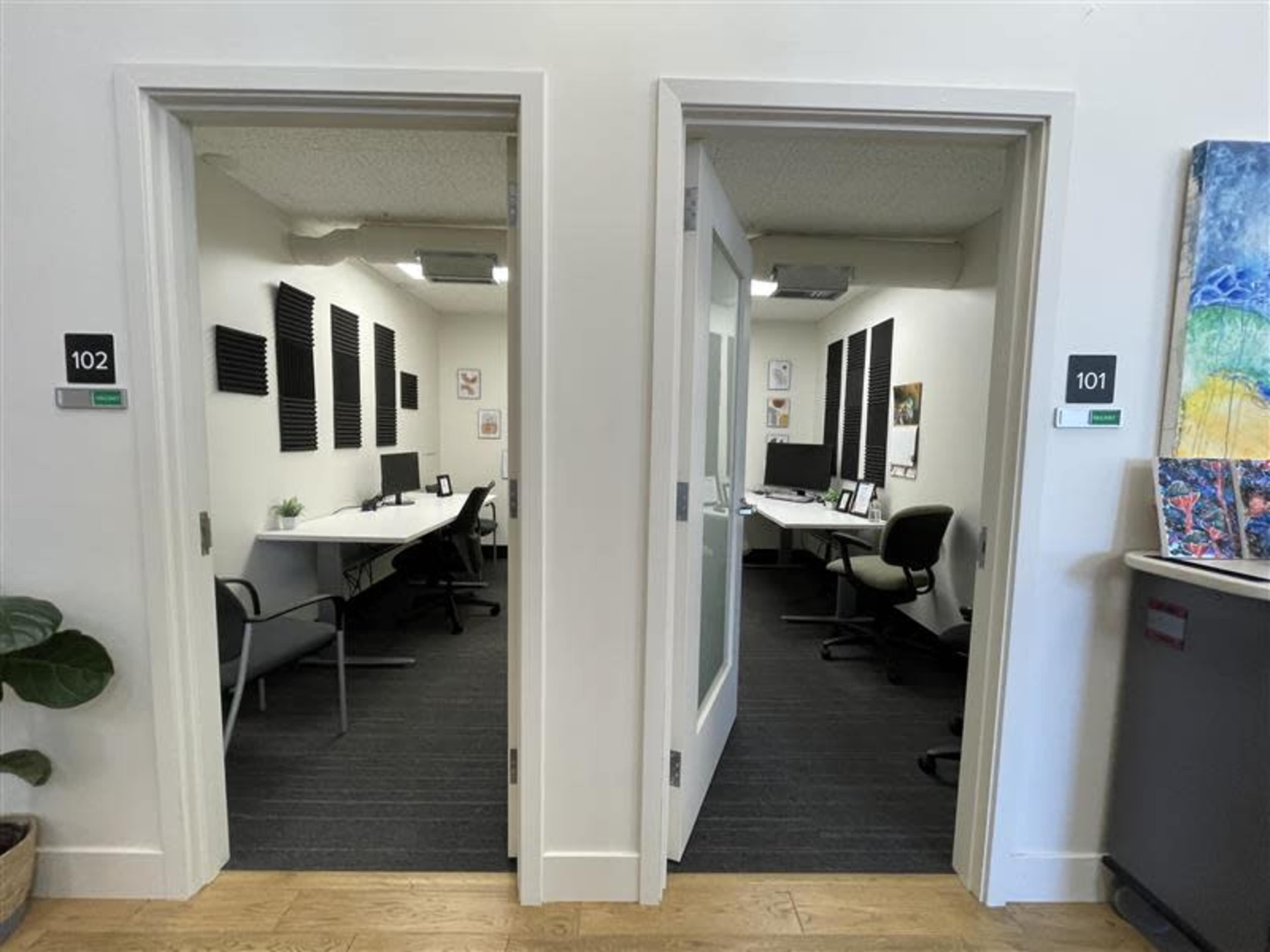 The image shows two office spaces, labeled 101 and 102, with desks and chairs inside, separated by glass doors.