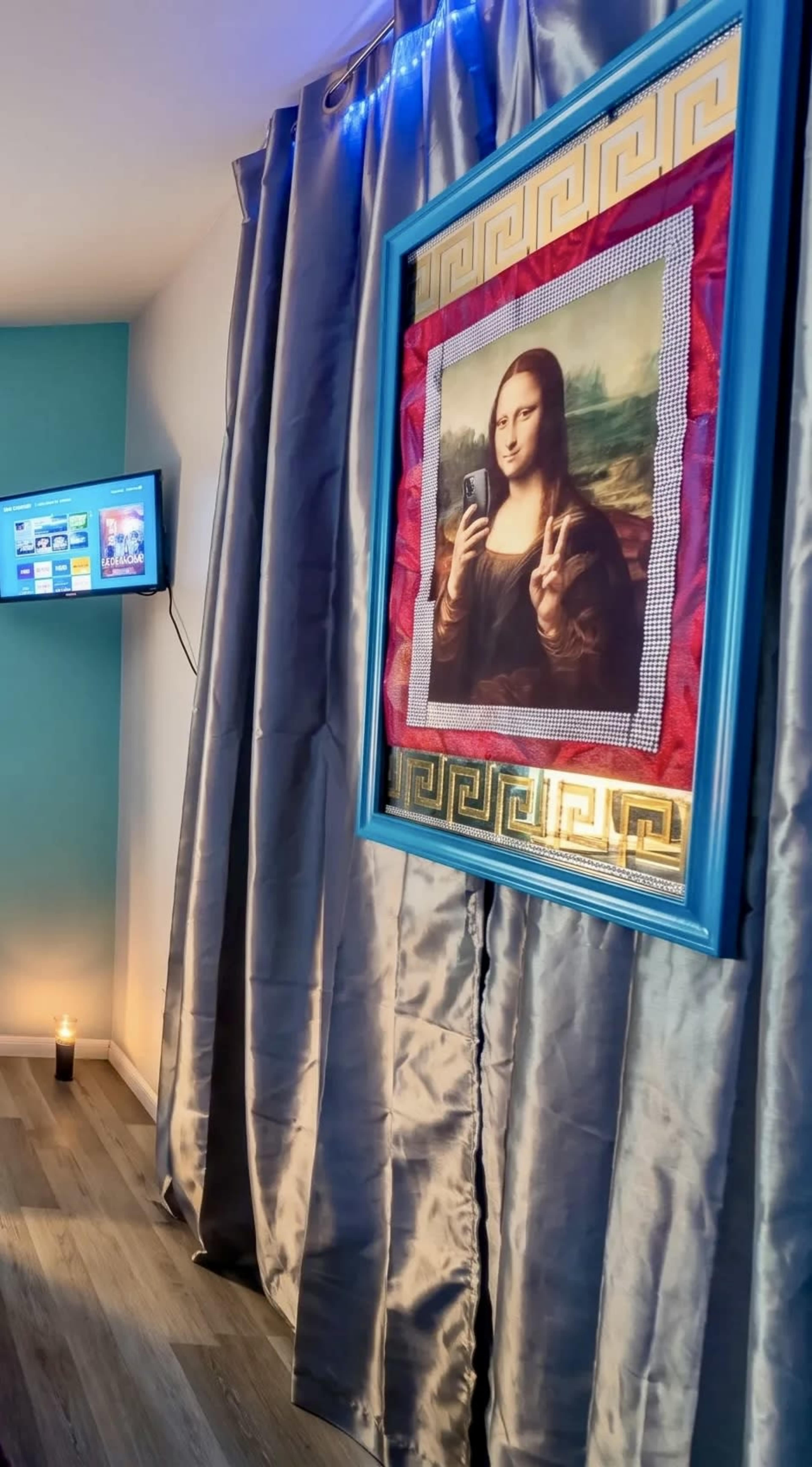 The image features a modern reinterpretation of the Mona Lisa framed prominently on a wall, with muted curtains and a television in the background.