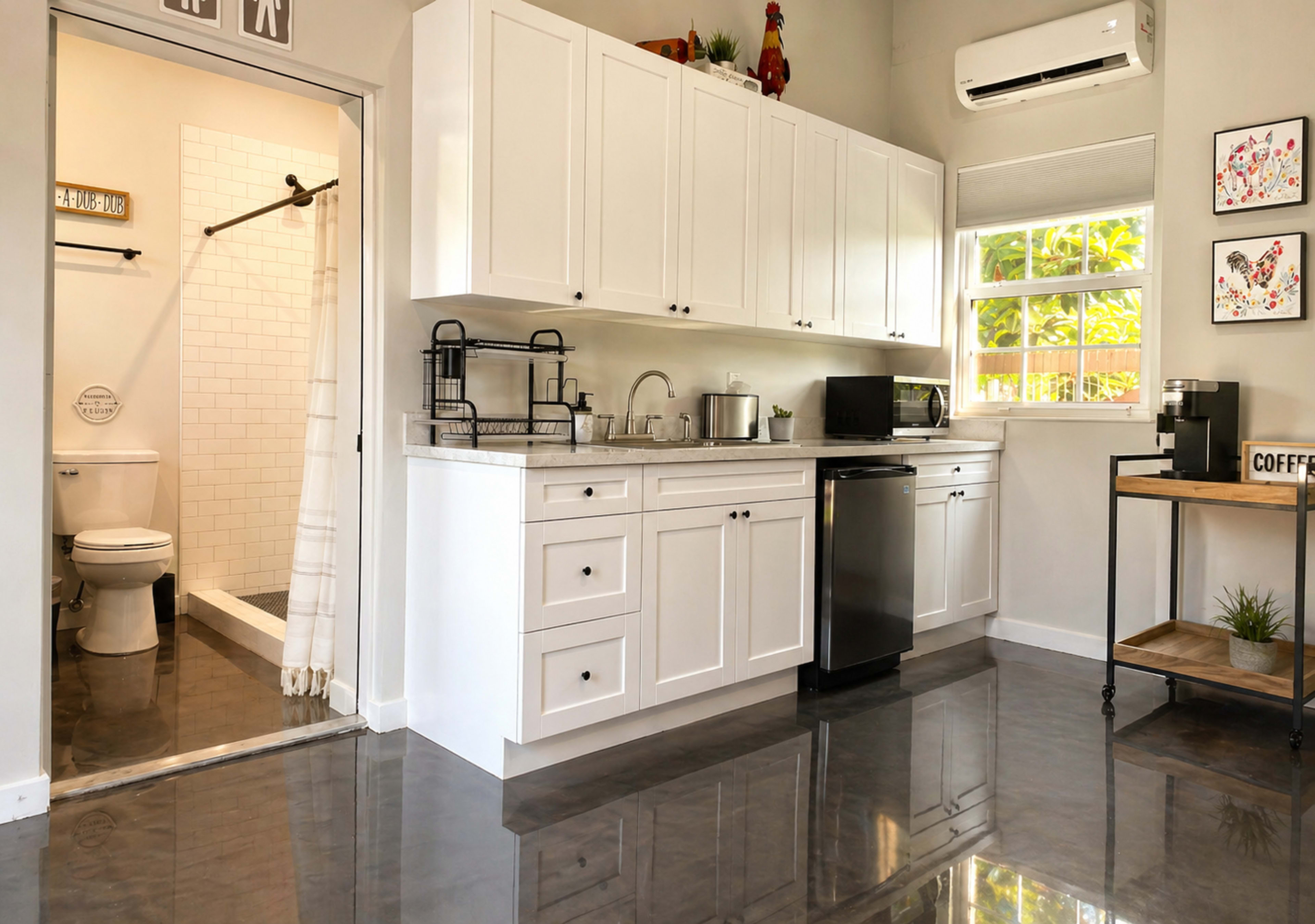 The image shows a modern kitchen with white cabinetry, stainless steel appliances, and an adjacent bathroom visible through a doorway.