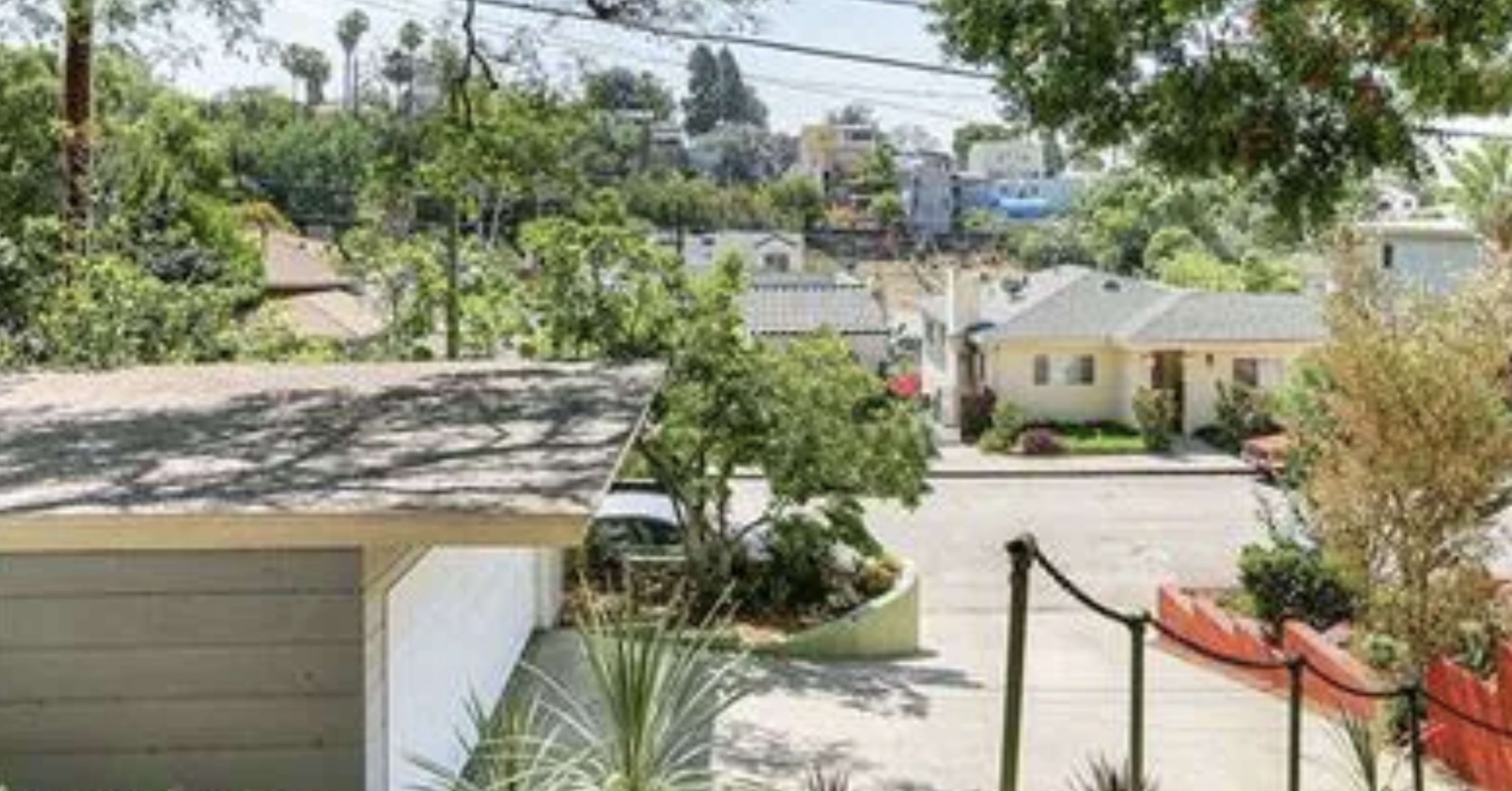 A residential neighborhood with a view of homes and trees, along with a driveway in the foreground.