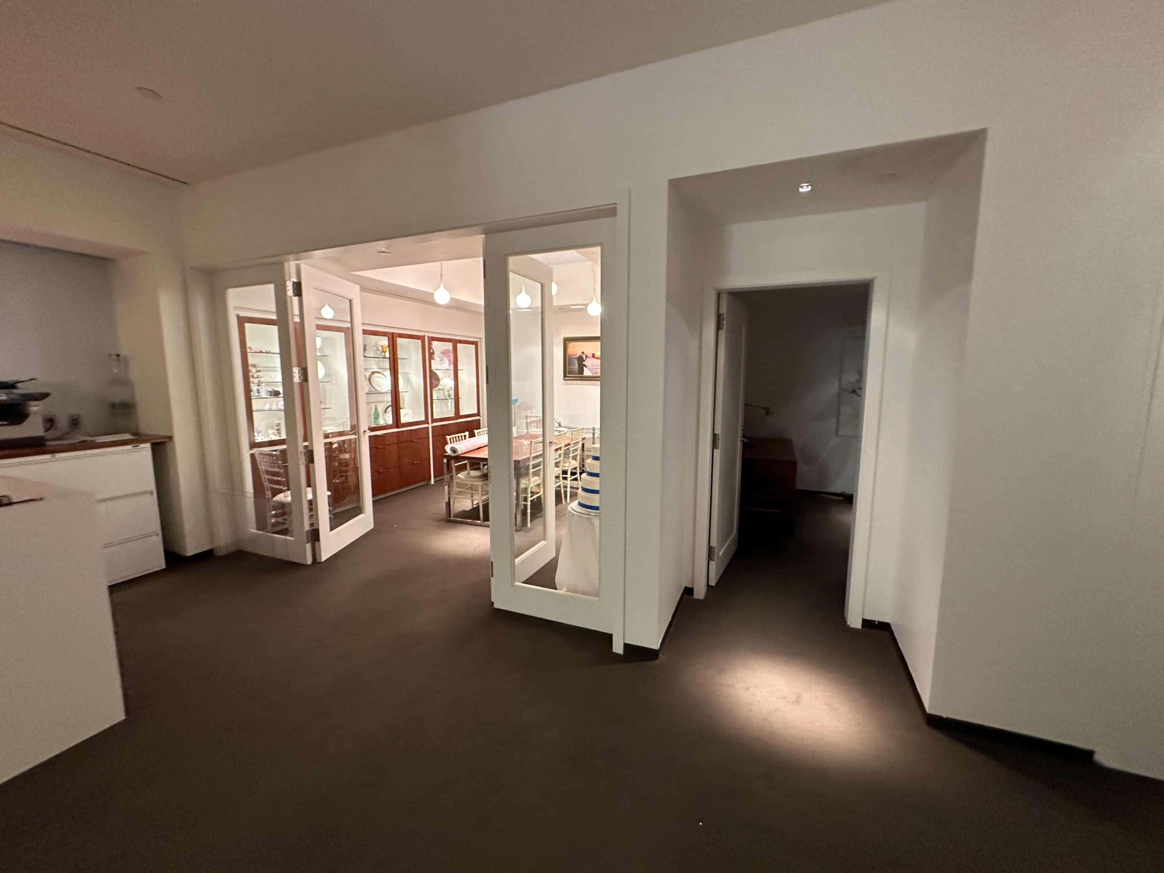 A spacious interior features a doorway leading to a dining area, with a hallway to the right and a kitchen area to the left.