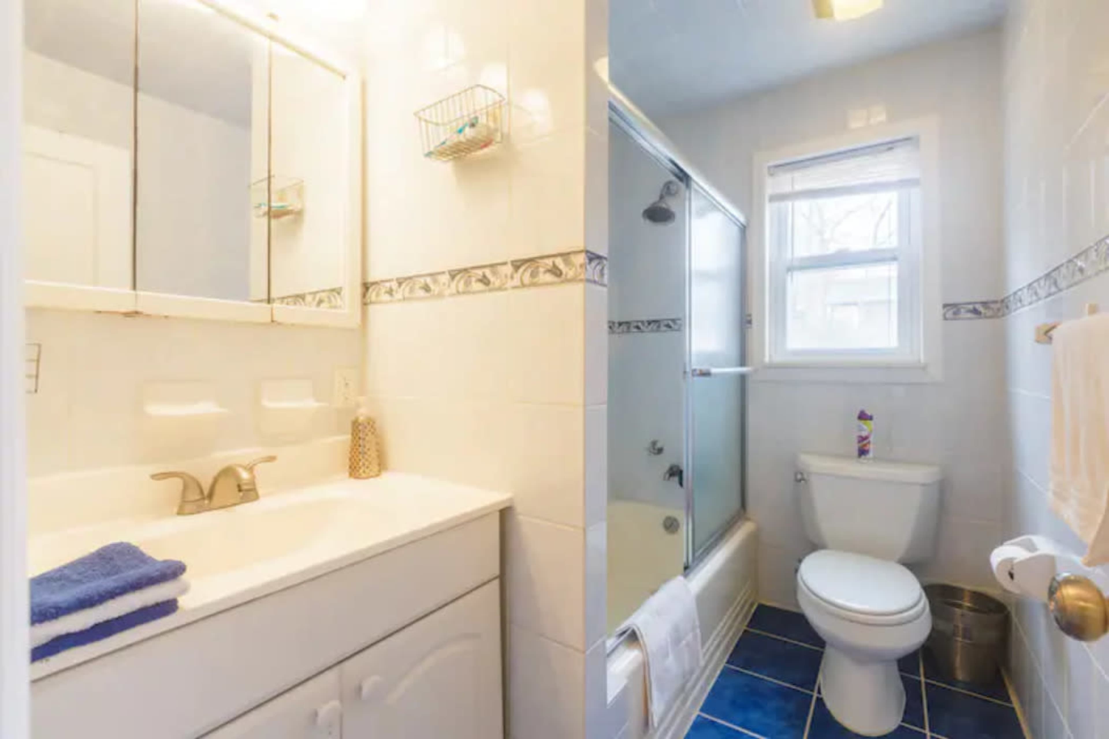 A small bathroom with a sink, mirror, and a separate shower enclosure next to a toilet.
