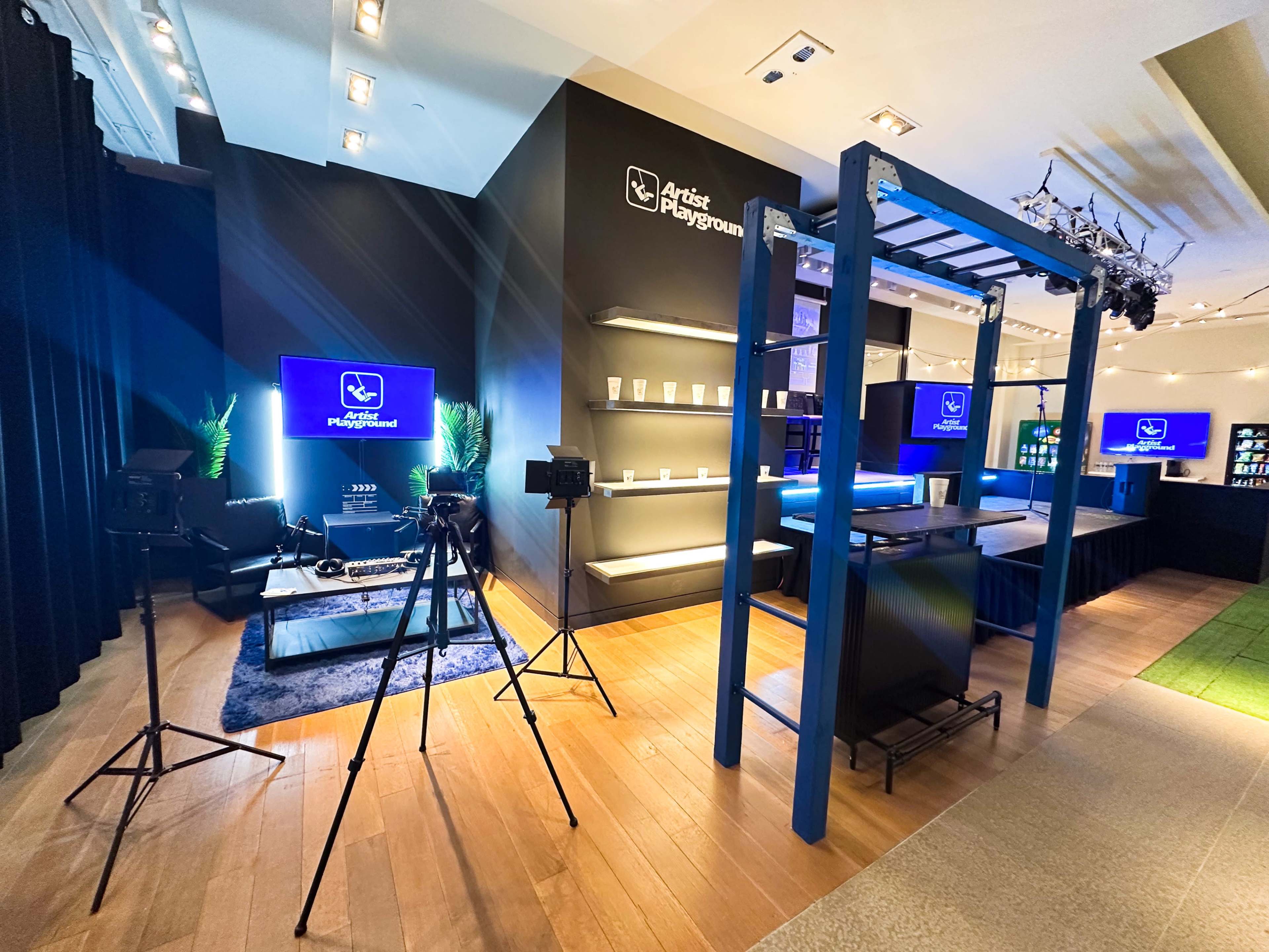 The image shows a modern studio space equipped with cameras, screens, and a decorative setup, labeled as "Artist Playground."