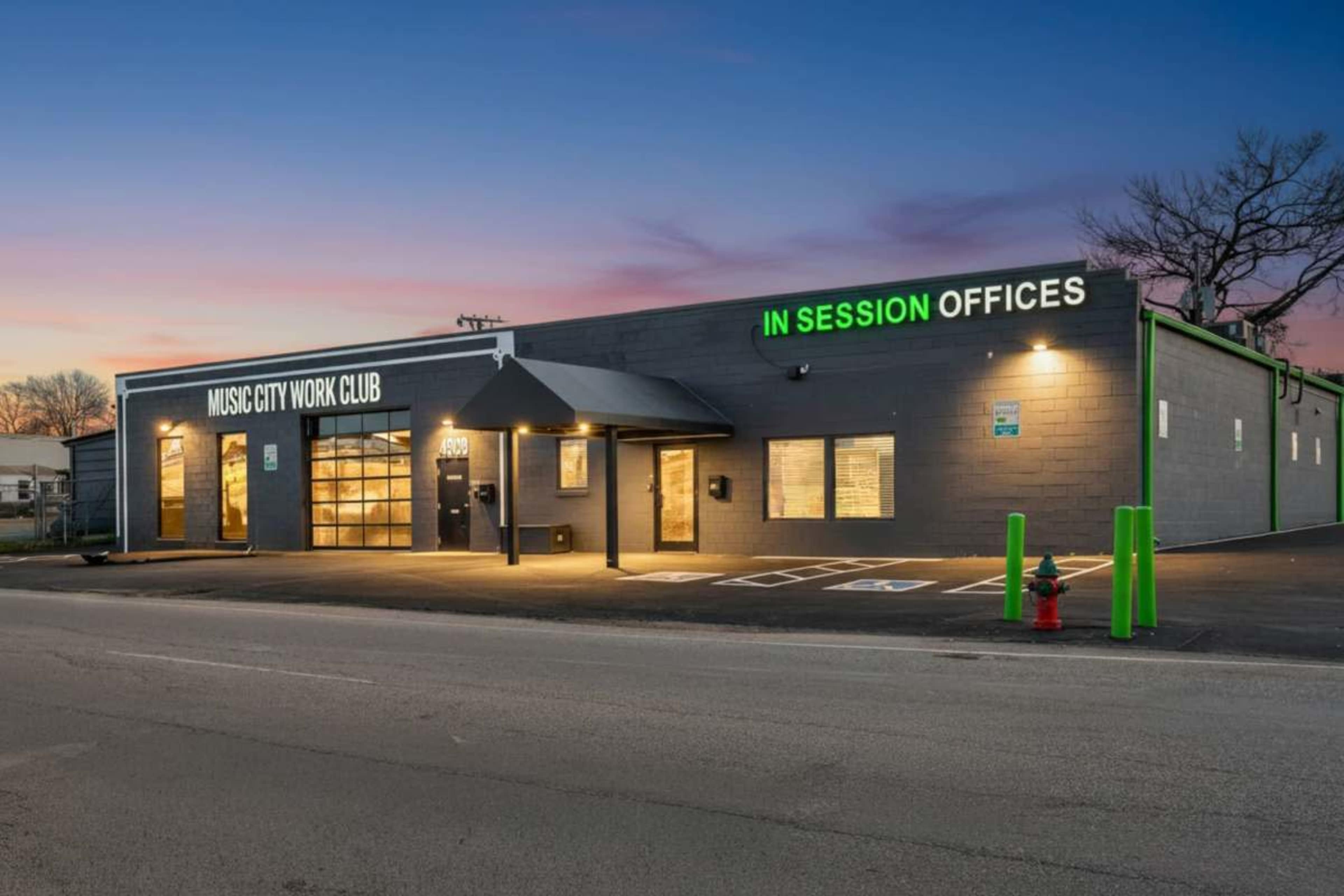 The image shows a low-rise commercial building with the signs "MUSIC CITY WORK CLUB" and "IN SESSION OFFICES" prominently displayed on the exterior.