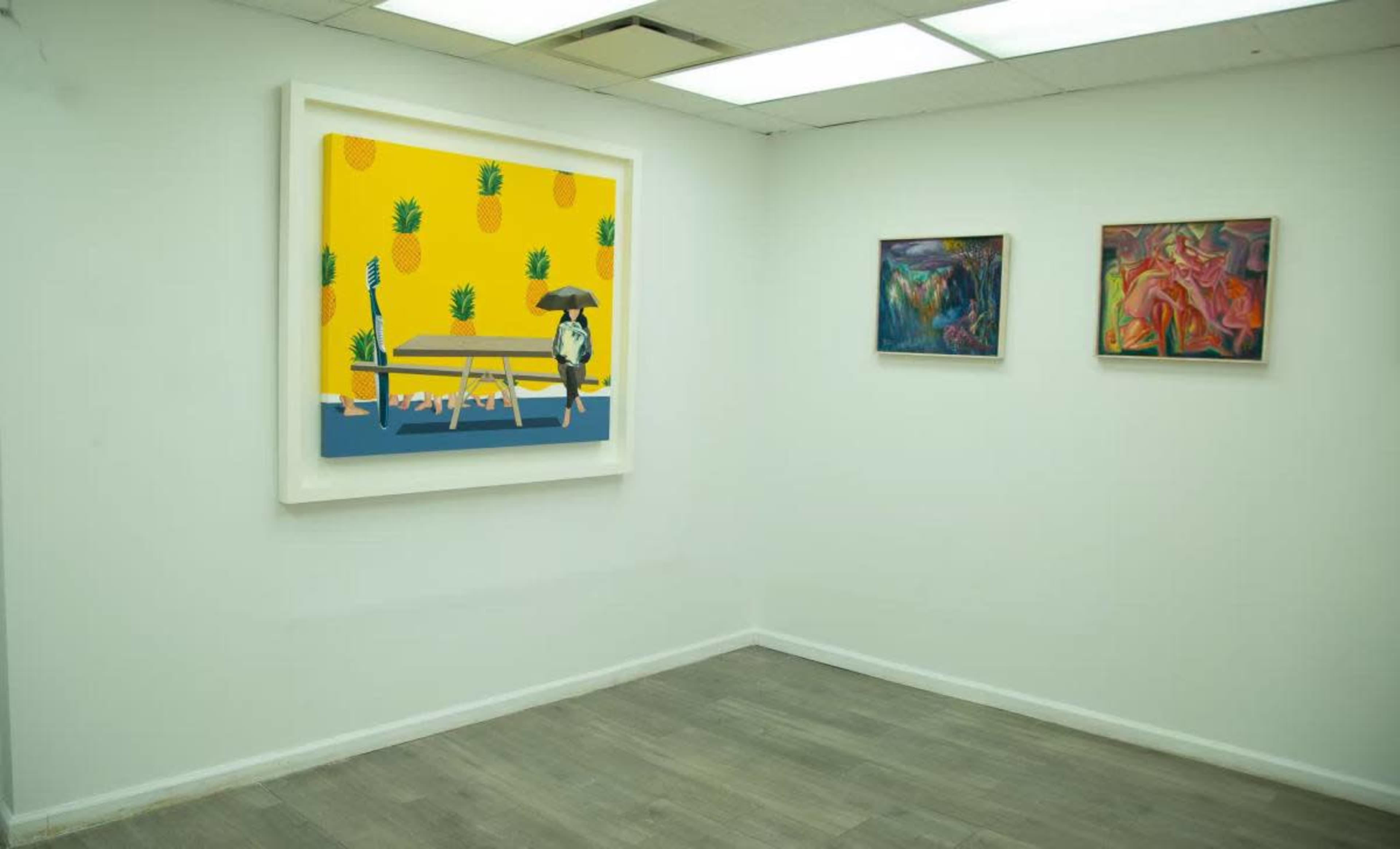 The image shows an art gallery with a large framed painting of a dog under an umbrella beside a picnic table on a bright yellow background, accompanied by two smaller framed artworks on the adjacent wall.