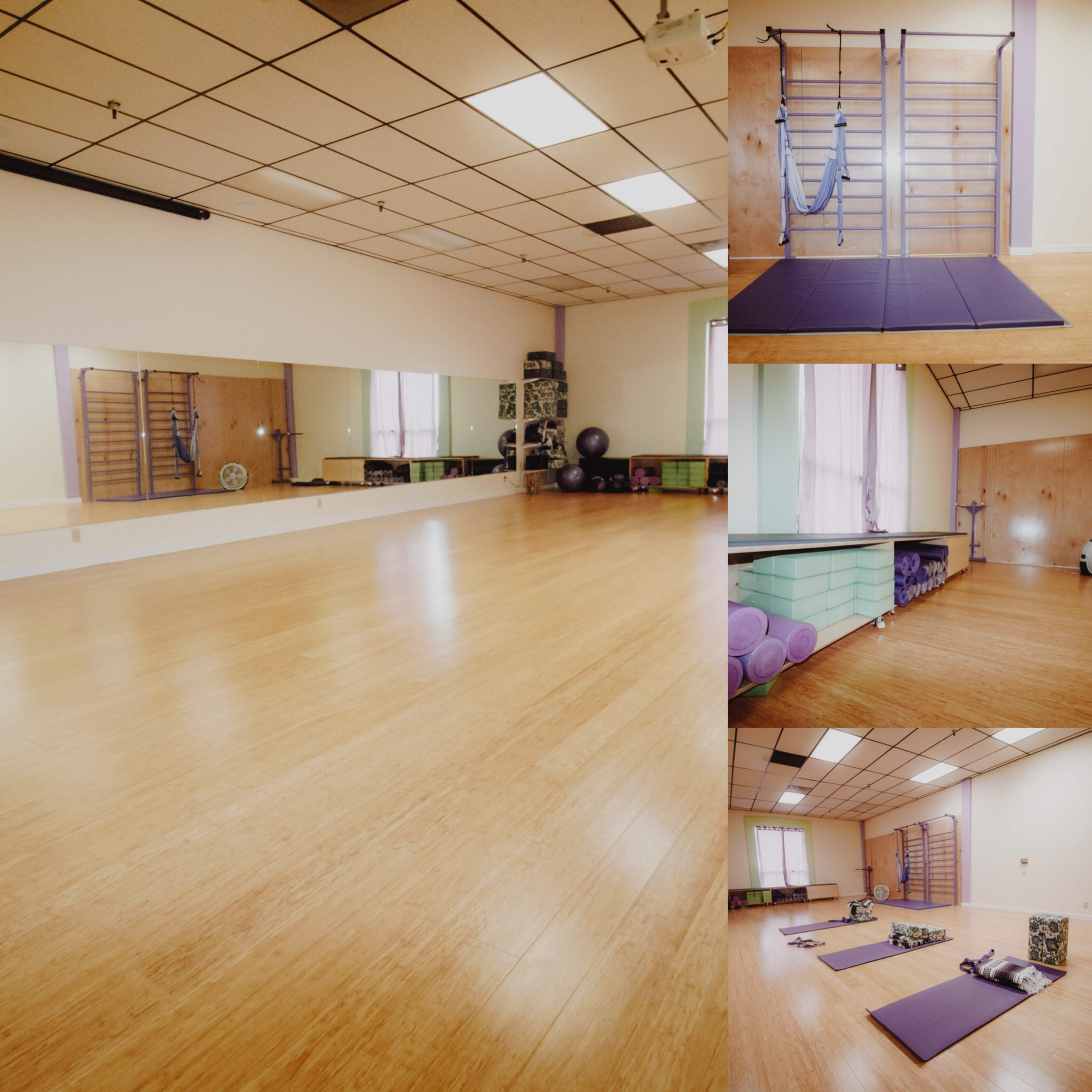 A spacious, wooden-floored yoga studio with various exercise equipment, including mats and stability balls, arranged neatly.