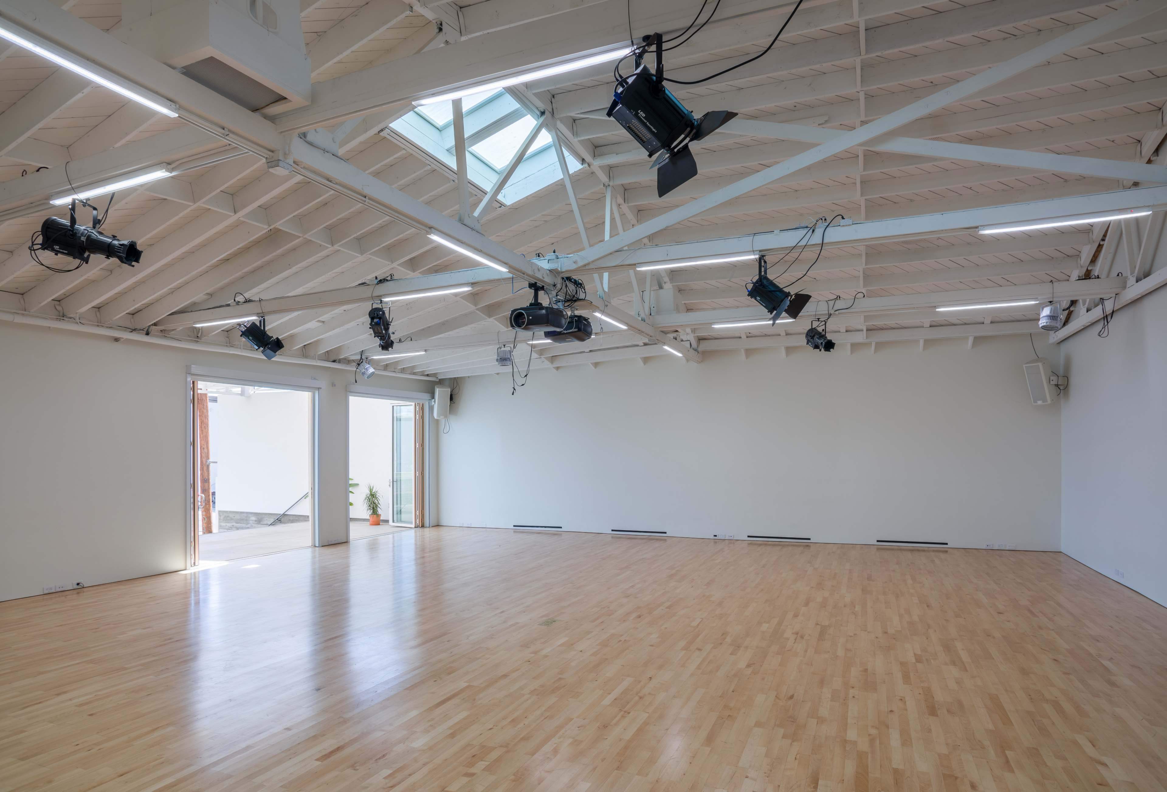 A spacious, well-lit interior with wooden flooring and multiple ceiling-mounted lights.