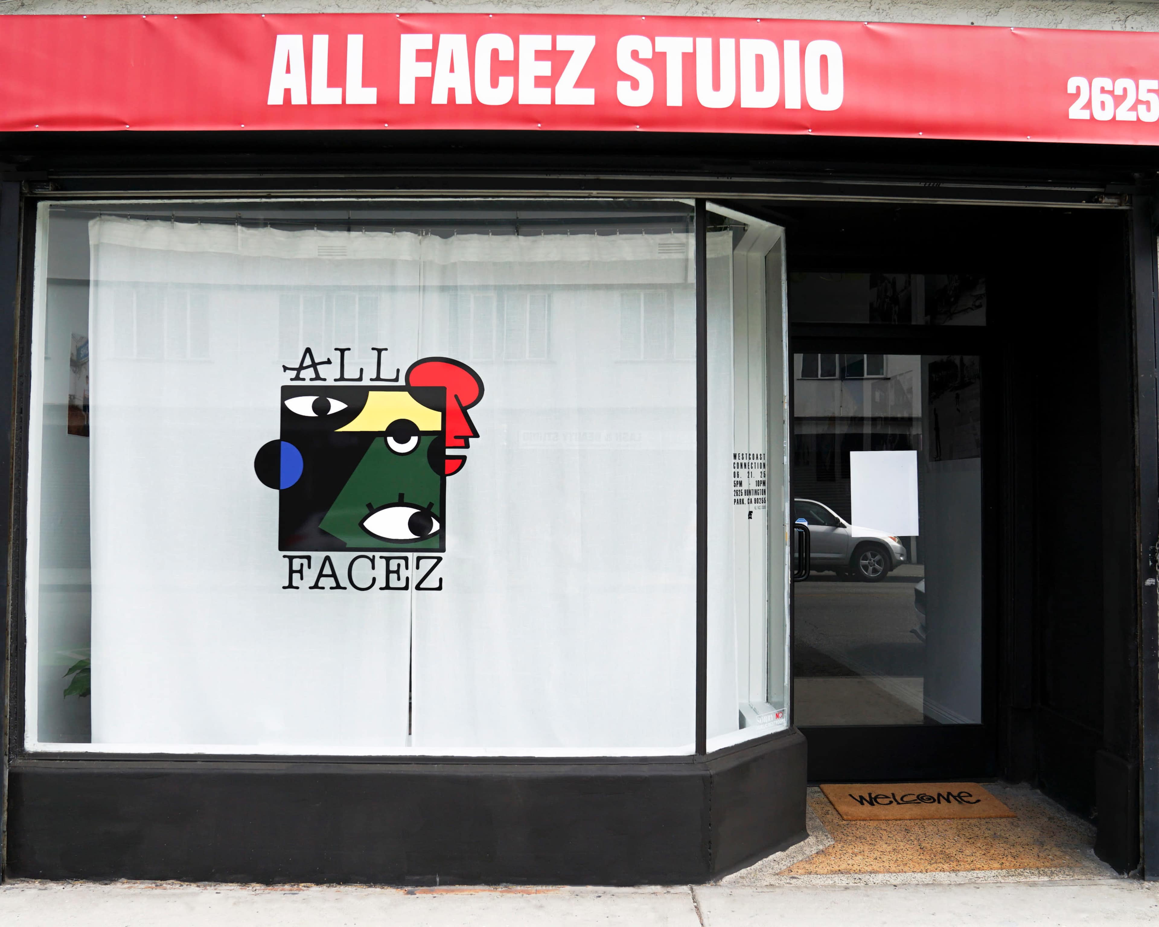 The image shows the entrance of a studio with a large sign reading "ALL FACEZ STUDIO" above a window featuring a colorful logo with abstract faces.