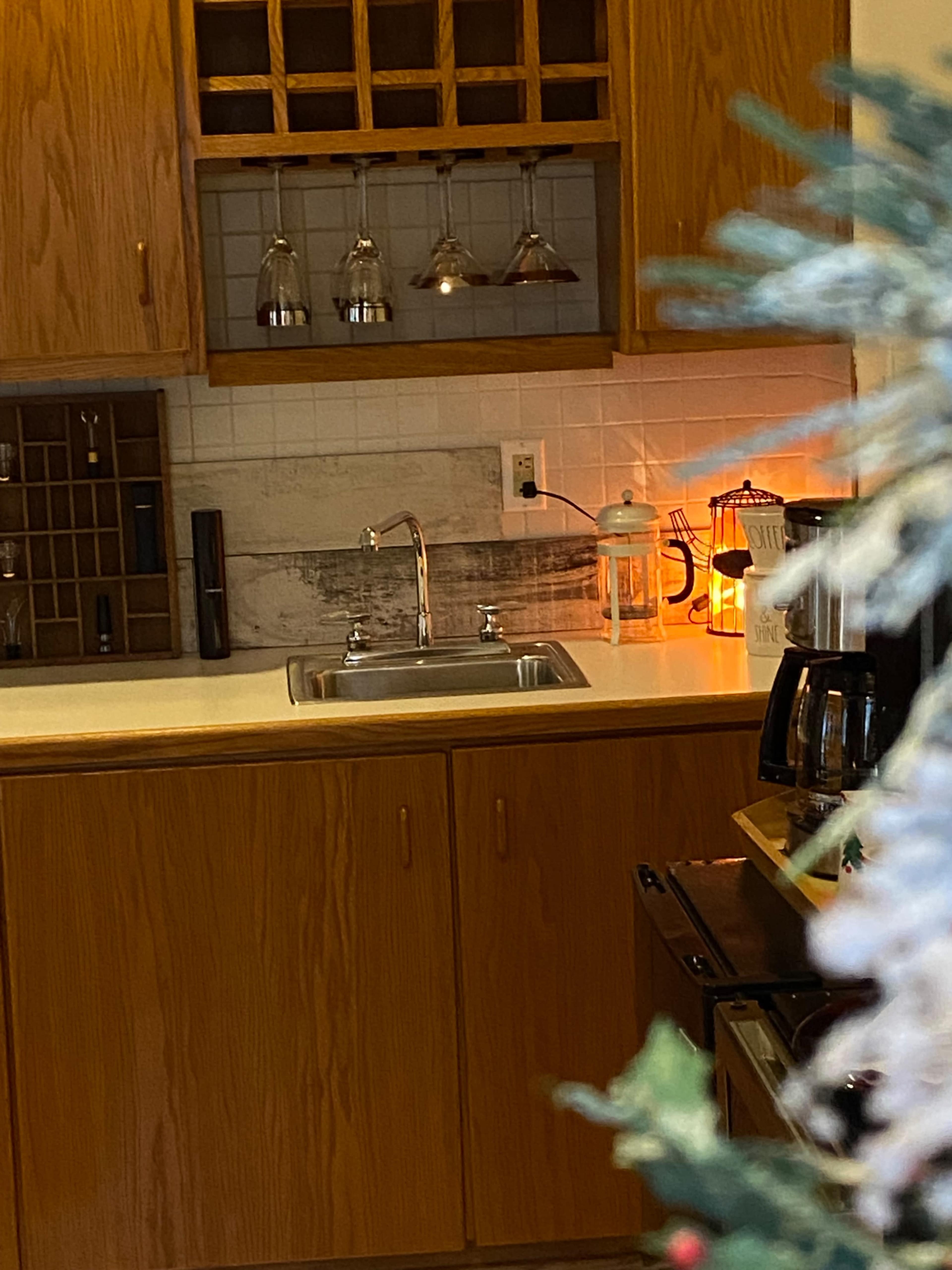 A kitchen with wooden cabinets, a sink, a coffee maker, and a decorative lantern.