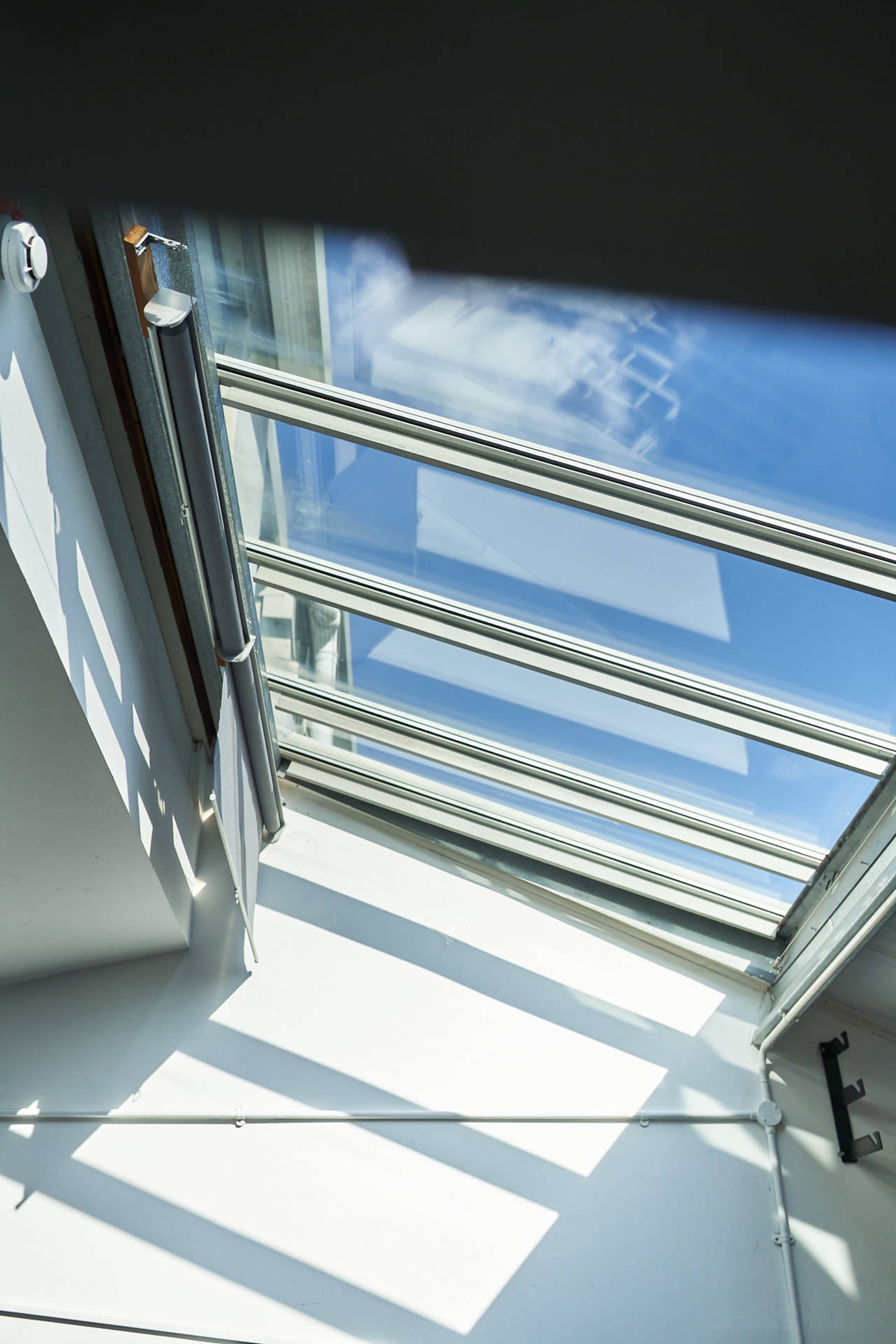 A skylight in a modern room, allowing sunlight to illuminate the white walls below.