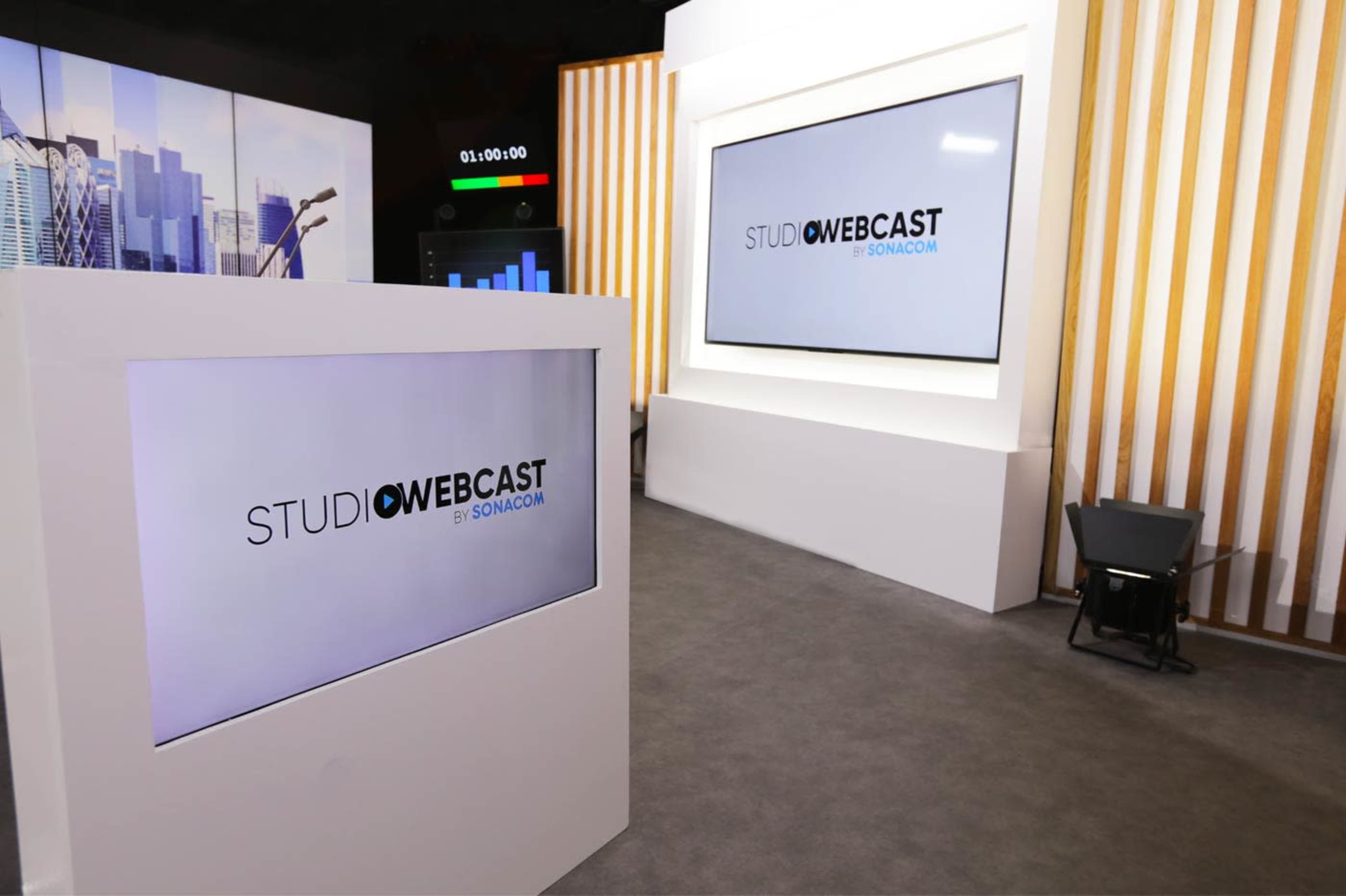 A modern studio setup with large screens displaying the logo "STUDIO WEBCAST by SONACOM."