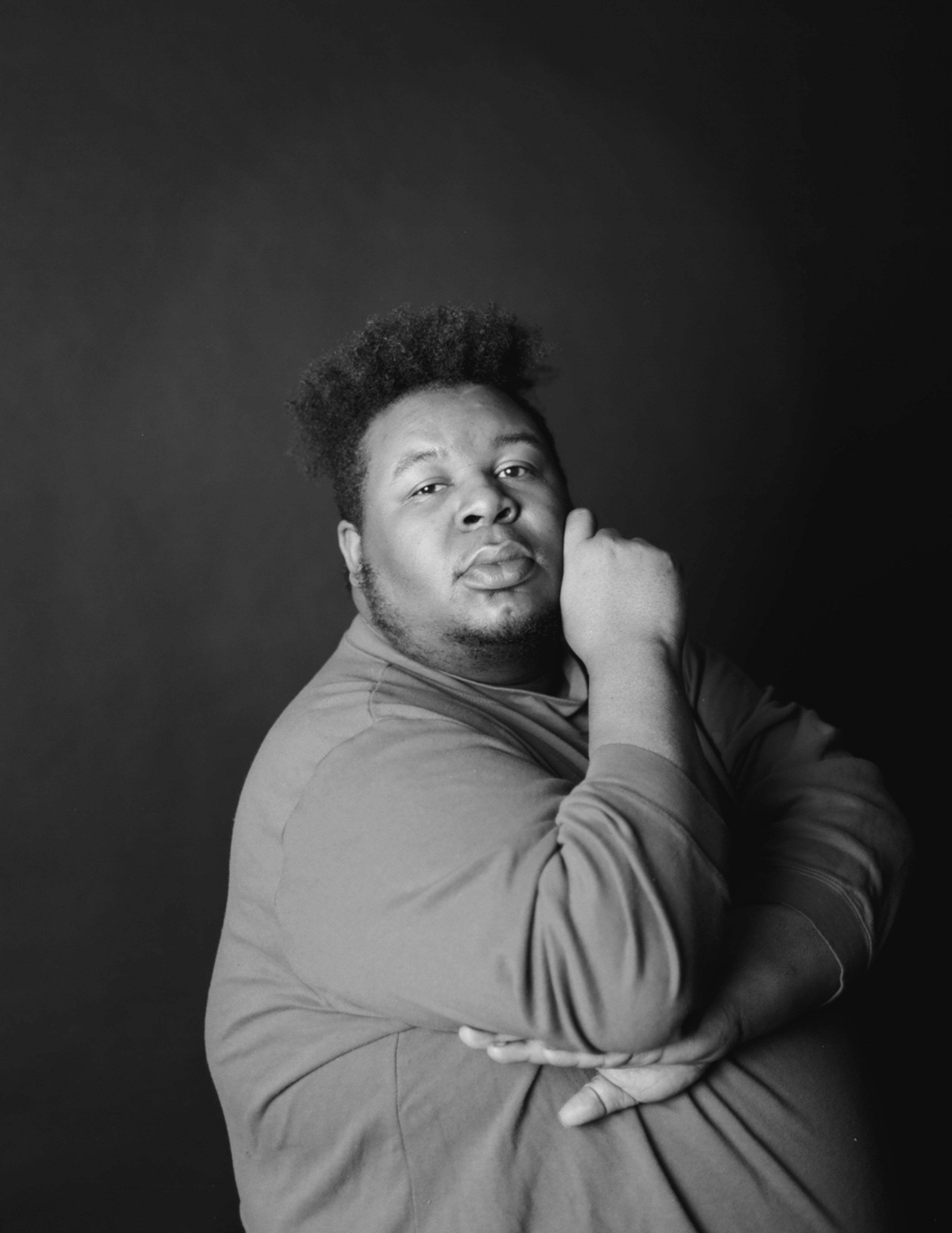 A black and white portrait of a man posing for a headshot photo.