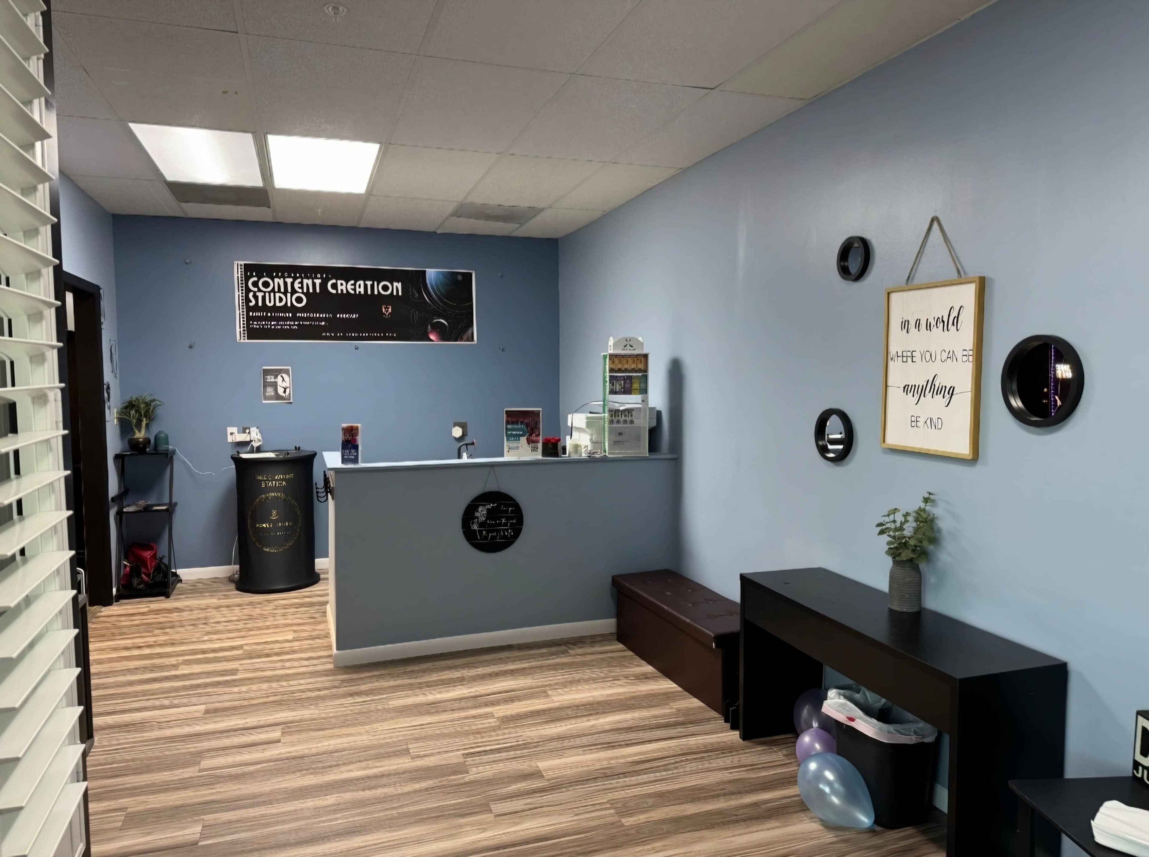 The interior of a content creation studio featuring a reception area with a desk, promotional signage, and decorative elements on the walls.