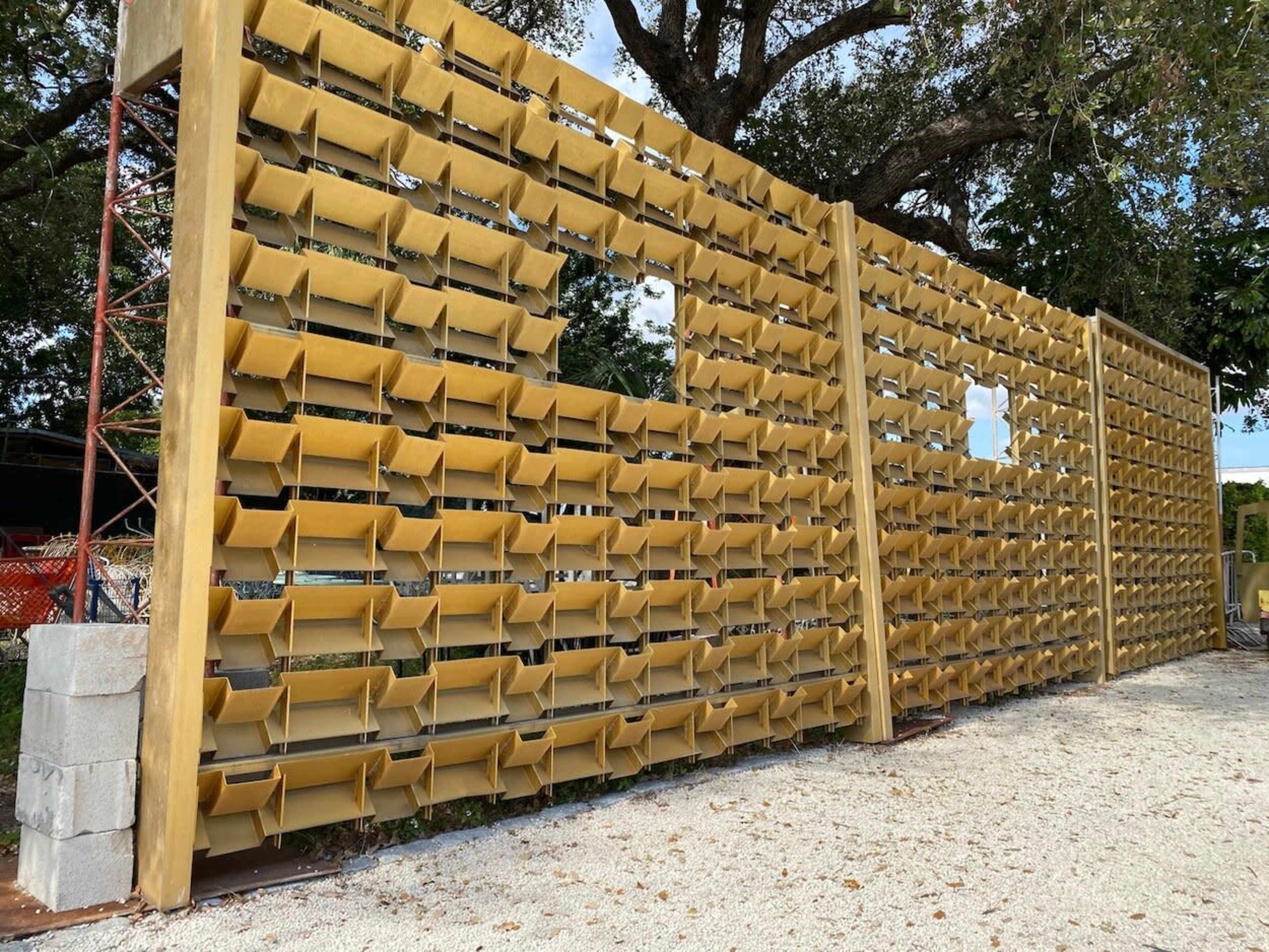 A wall made of multiple golden-colored bins arranged in a grid pattern with a few missing sections.